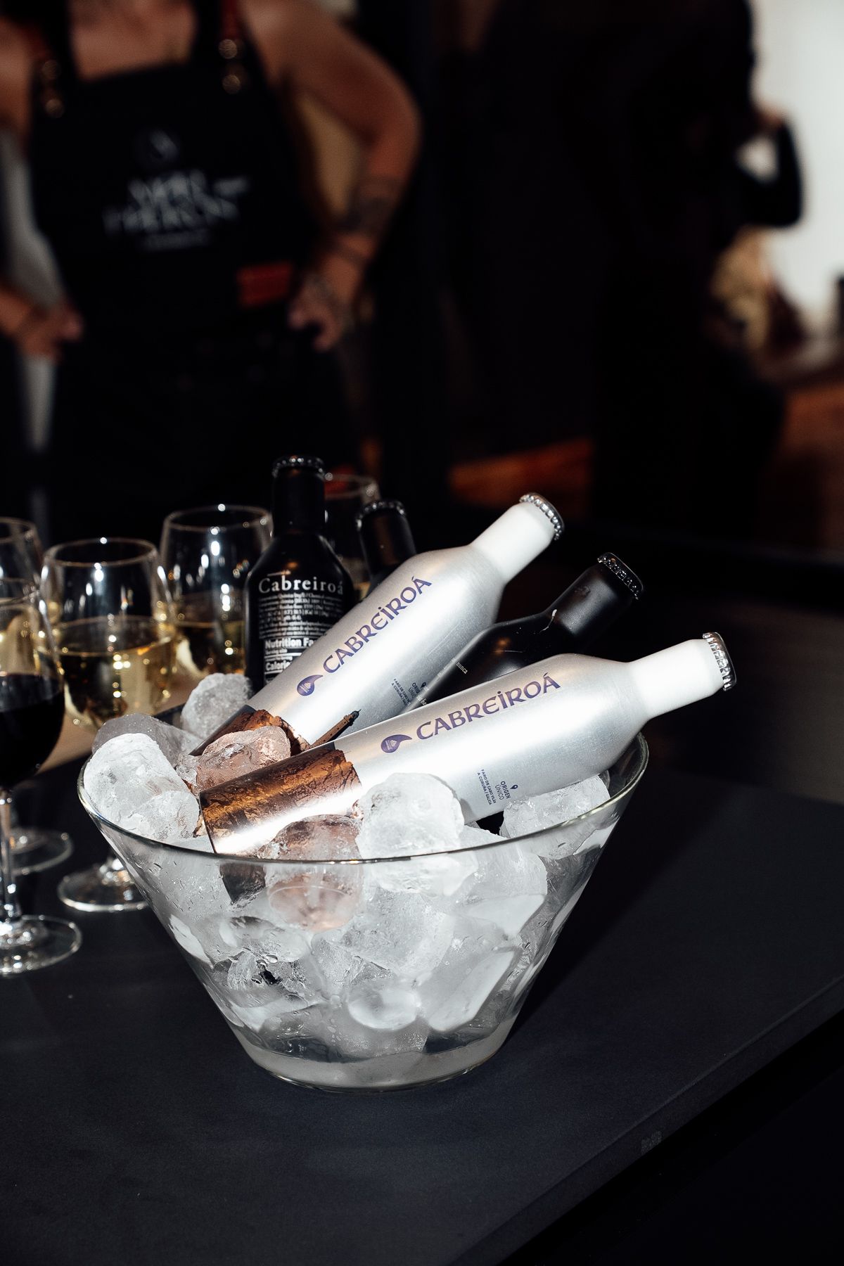 Cabreiroa water bottles chilling in ice bowl at Gran Diosa event with wine glasses nearby.