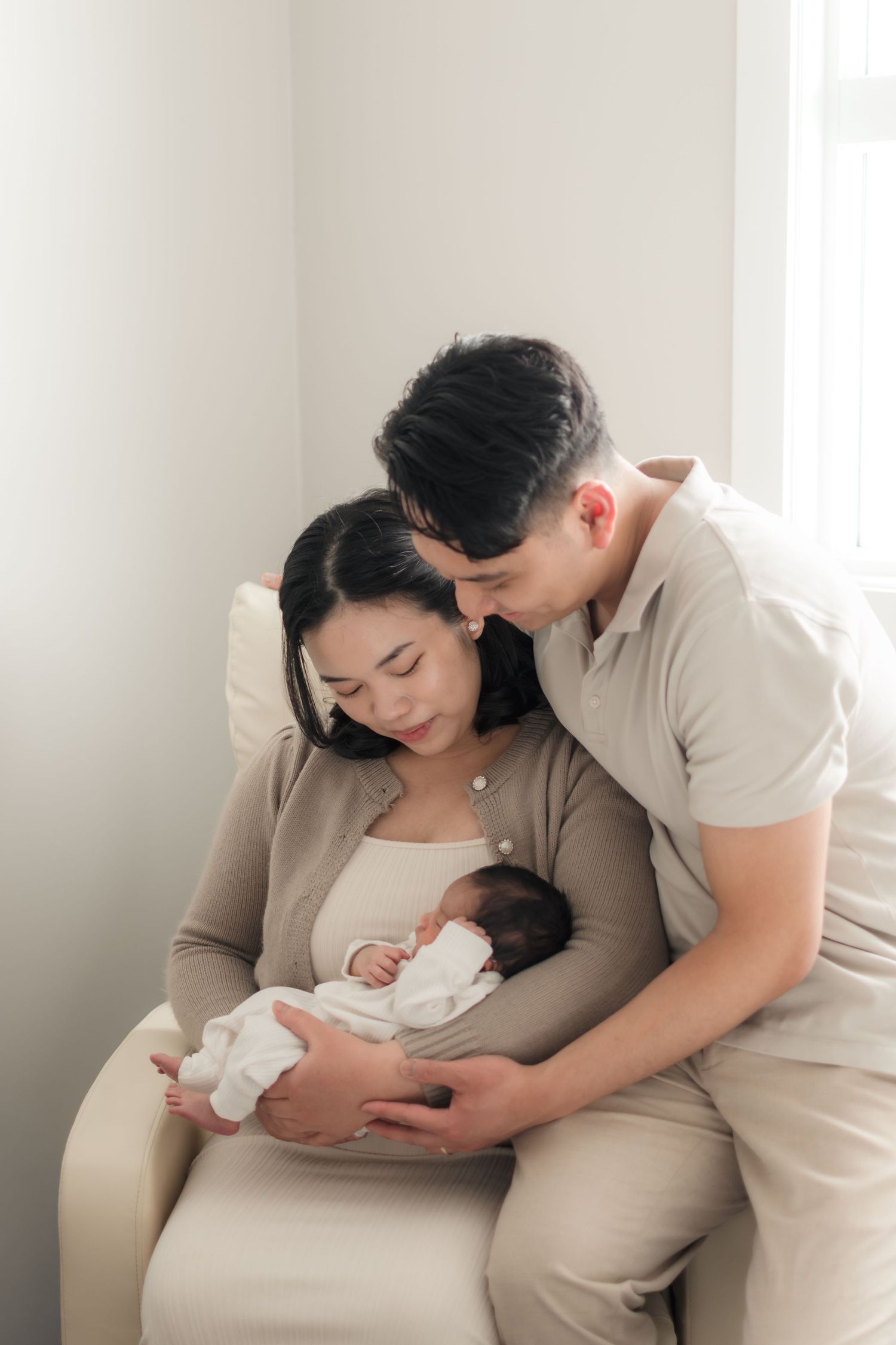 Mother and Father holding newborn during in-home session in Saskatoon