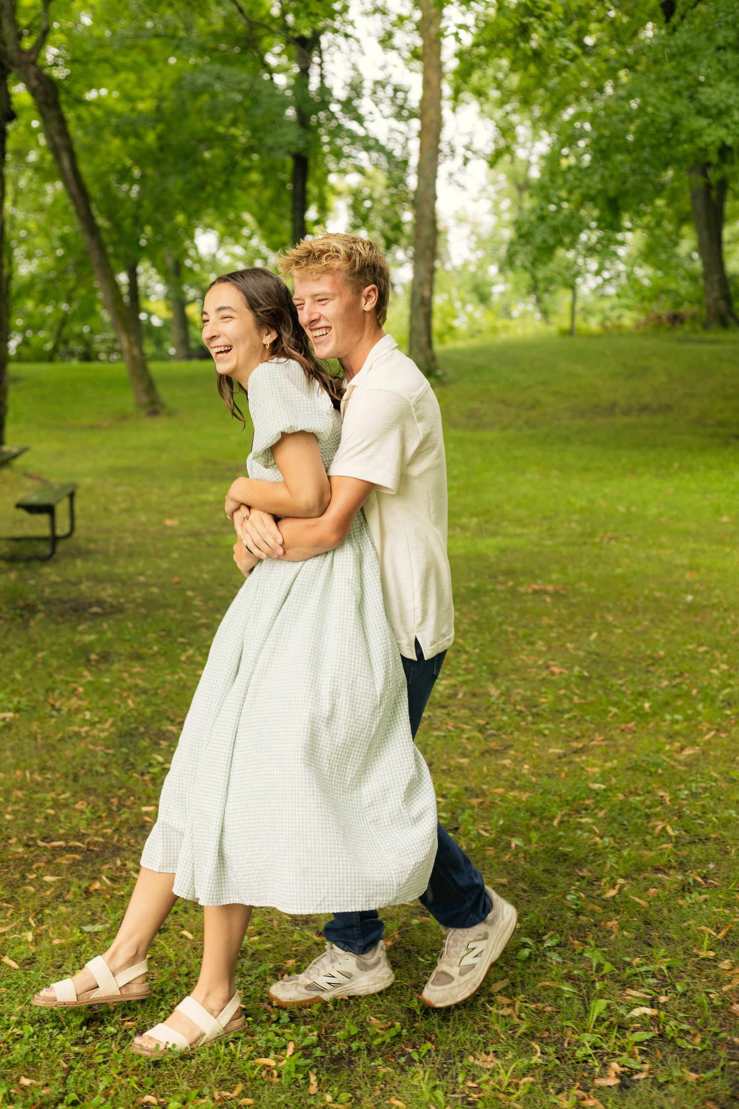 Couple laughing and hugging in the grass at Lake Carlos State Park in Alexandria, Minnesota