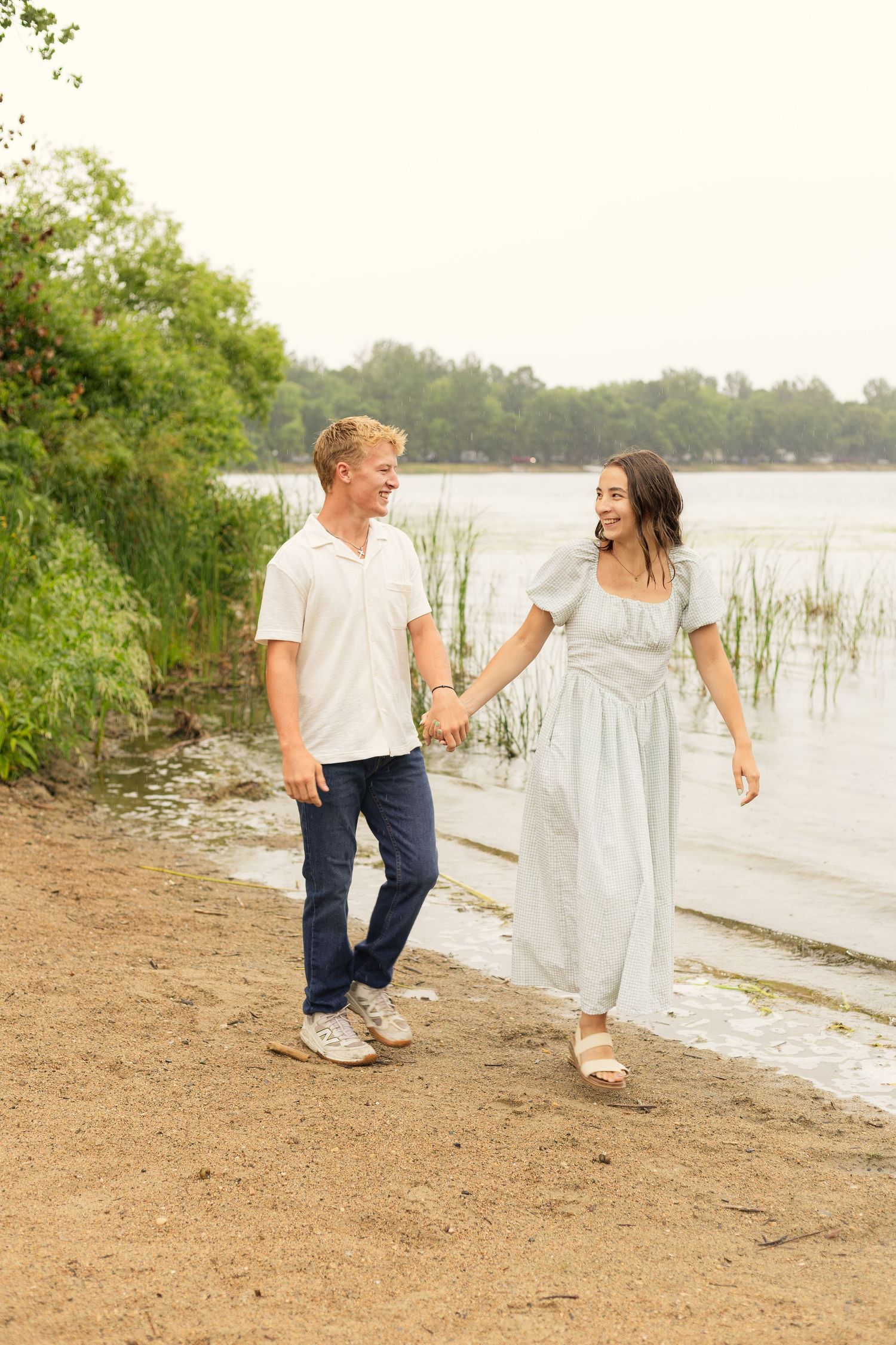 Couple walking along the beach smiling at Lake Carlos State Park in Alexandria, Minnesota