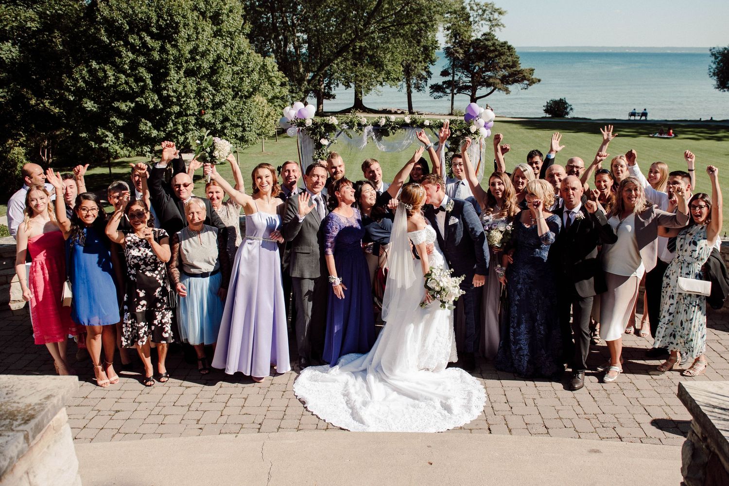 A wedding group shot in front of the lake at Paletta Mansion