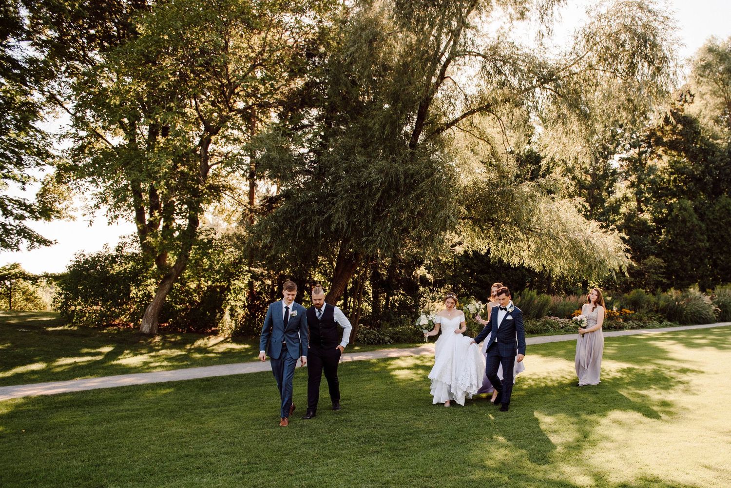 A bridal party walks along the grounds of Paletta Mansion