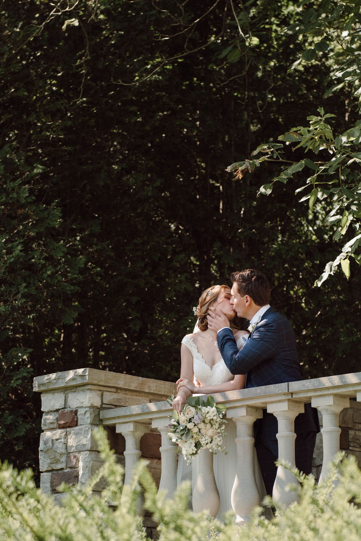 The bride and groom share a kiss on the balcony of Paletta Mansion