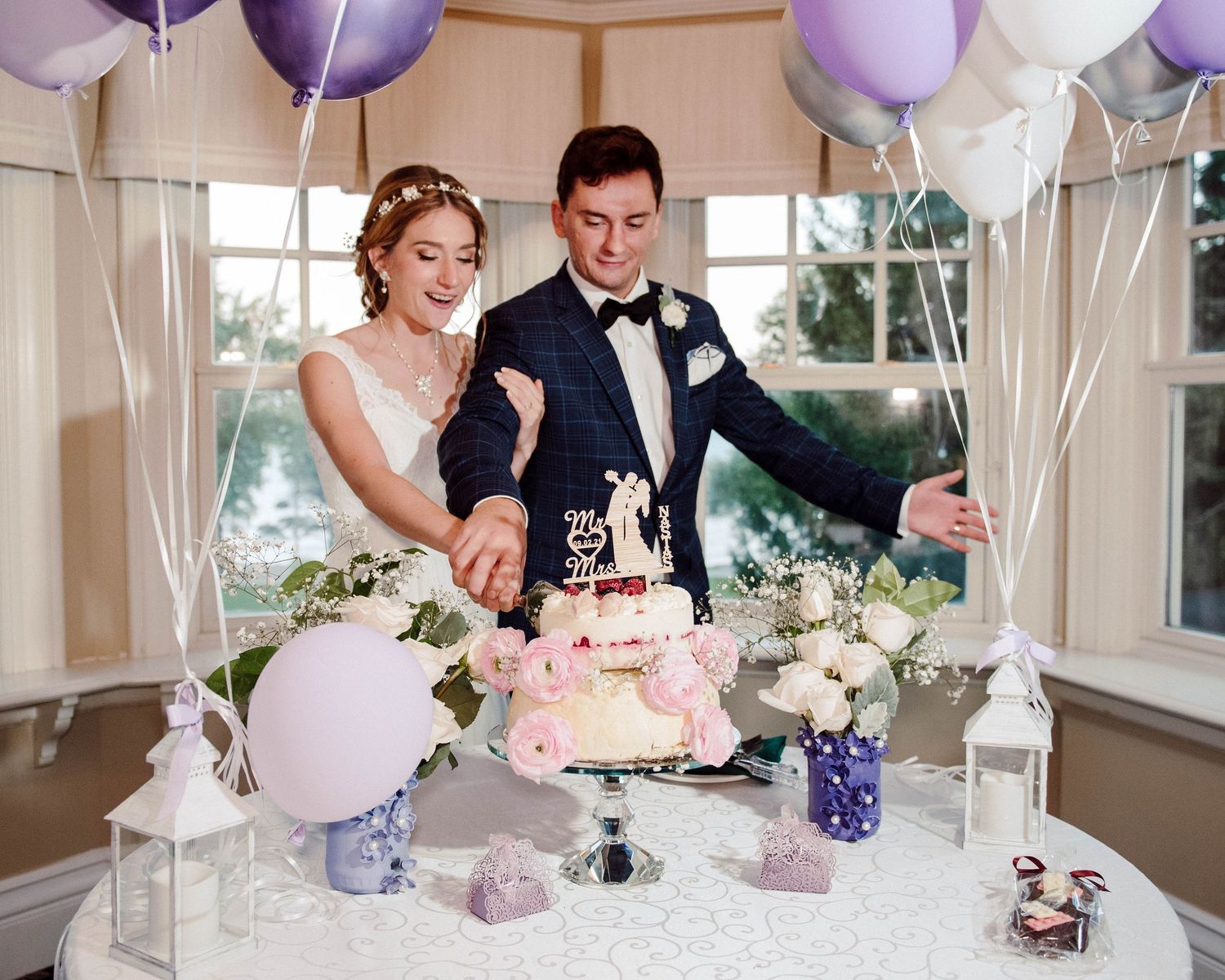 A bride and groom cut their cake in the Grand Room at Paletta Mansion