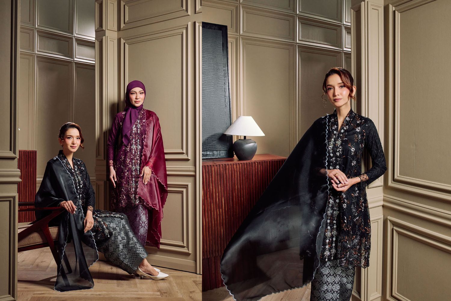 Three women showcasing black, purple, and dark floral baju kurung designs in sophisticated interior.