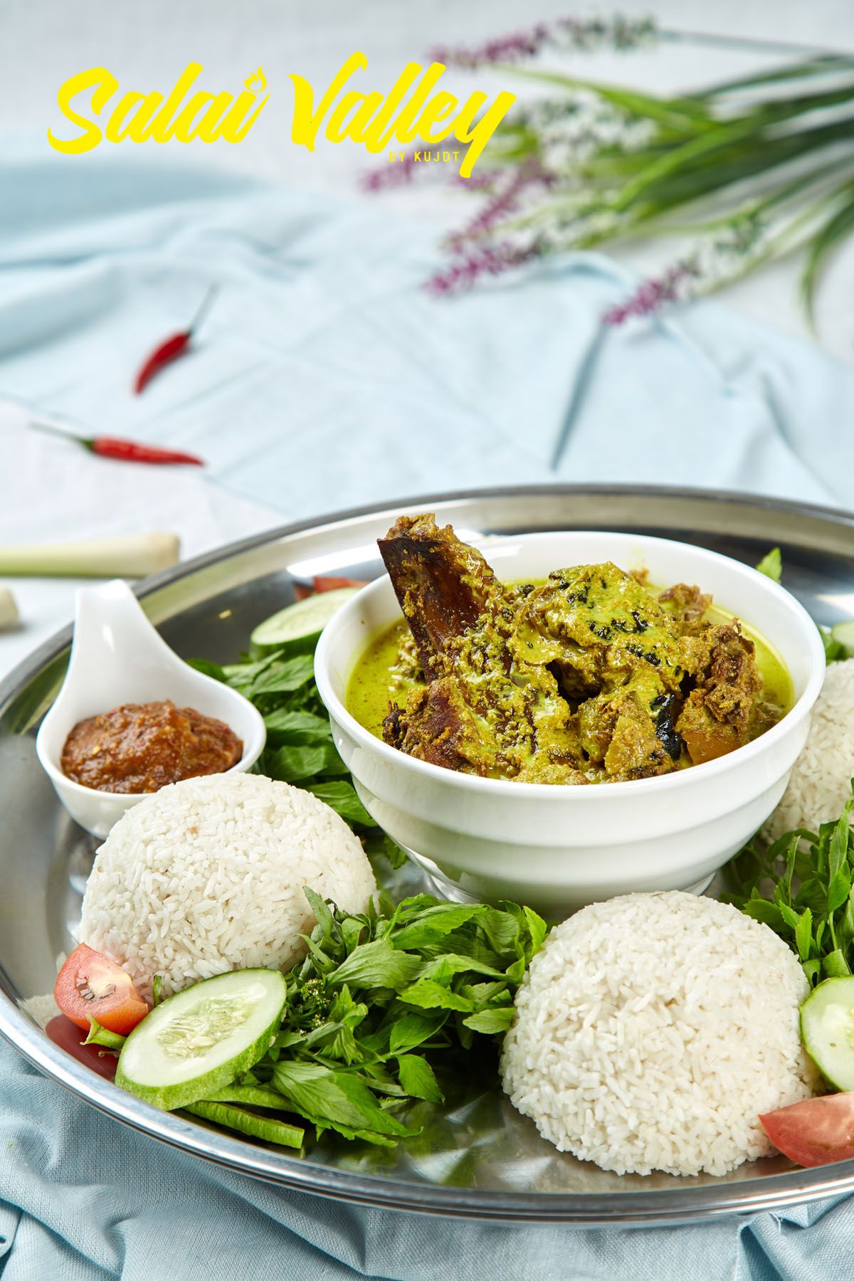 Salai Valley traditional rice set meal served on silver tray with curry, sambal, fresh herbs, and vegetables.