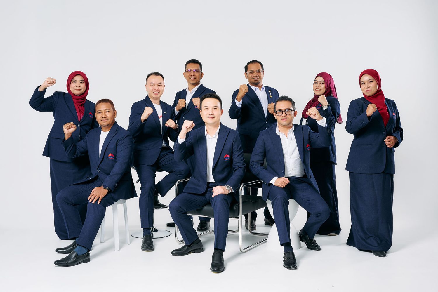 Group of nine professionals in navy blue uniforms posing confidently against a white background.