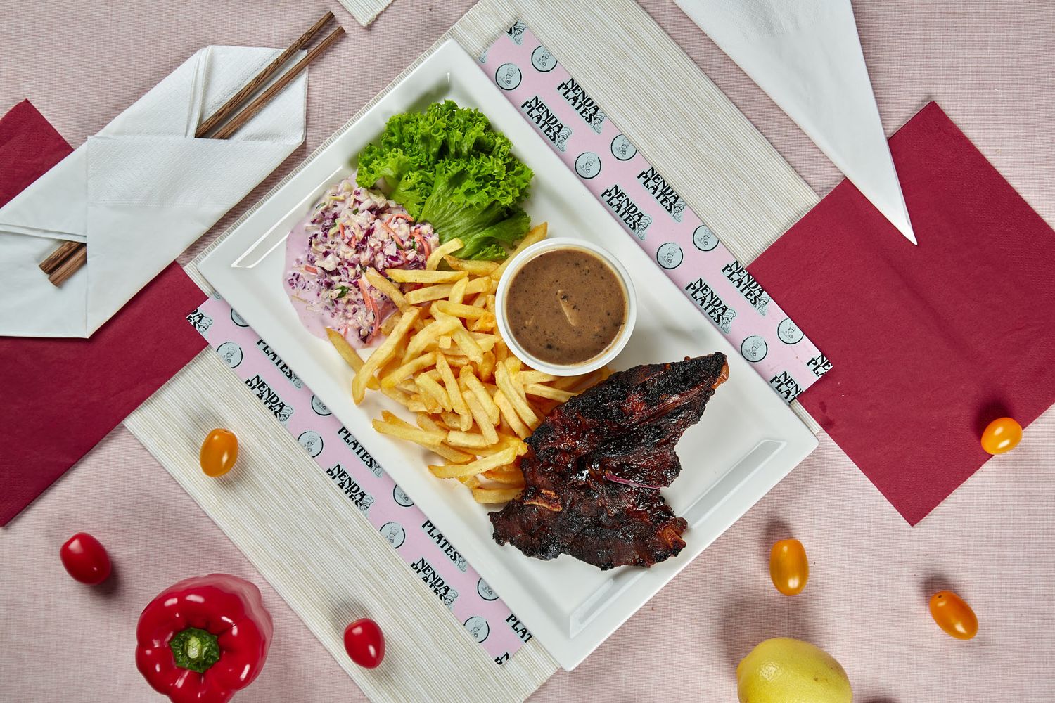 Grilled BBQ ribs with french fries, coleslaw, lettuce, and brown sauce on white plate, top view.