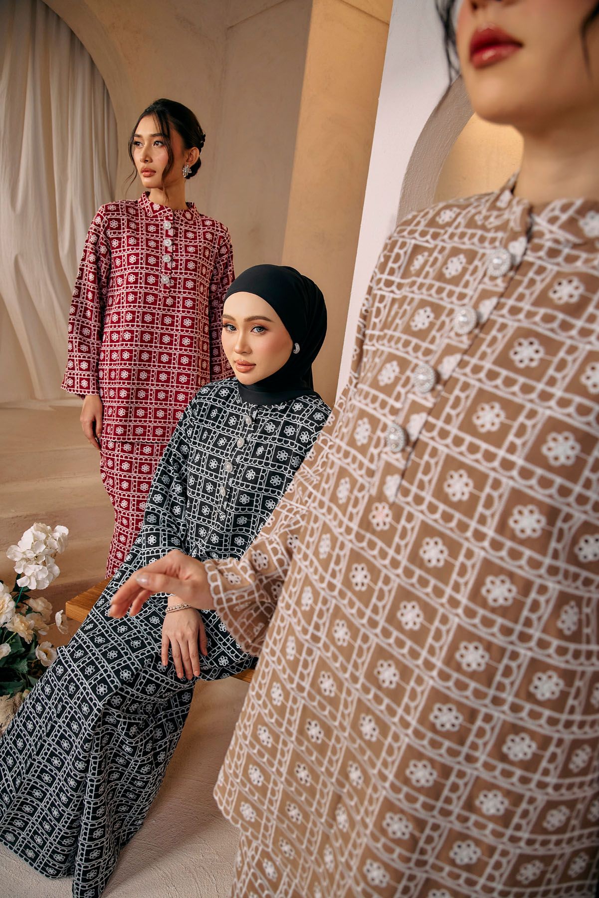 Three models wearing printed baju kurung in red, black, and beige geometric patterns in styled studio.