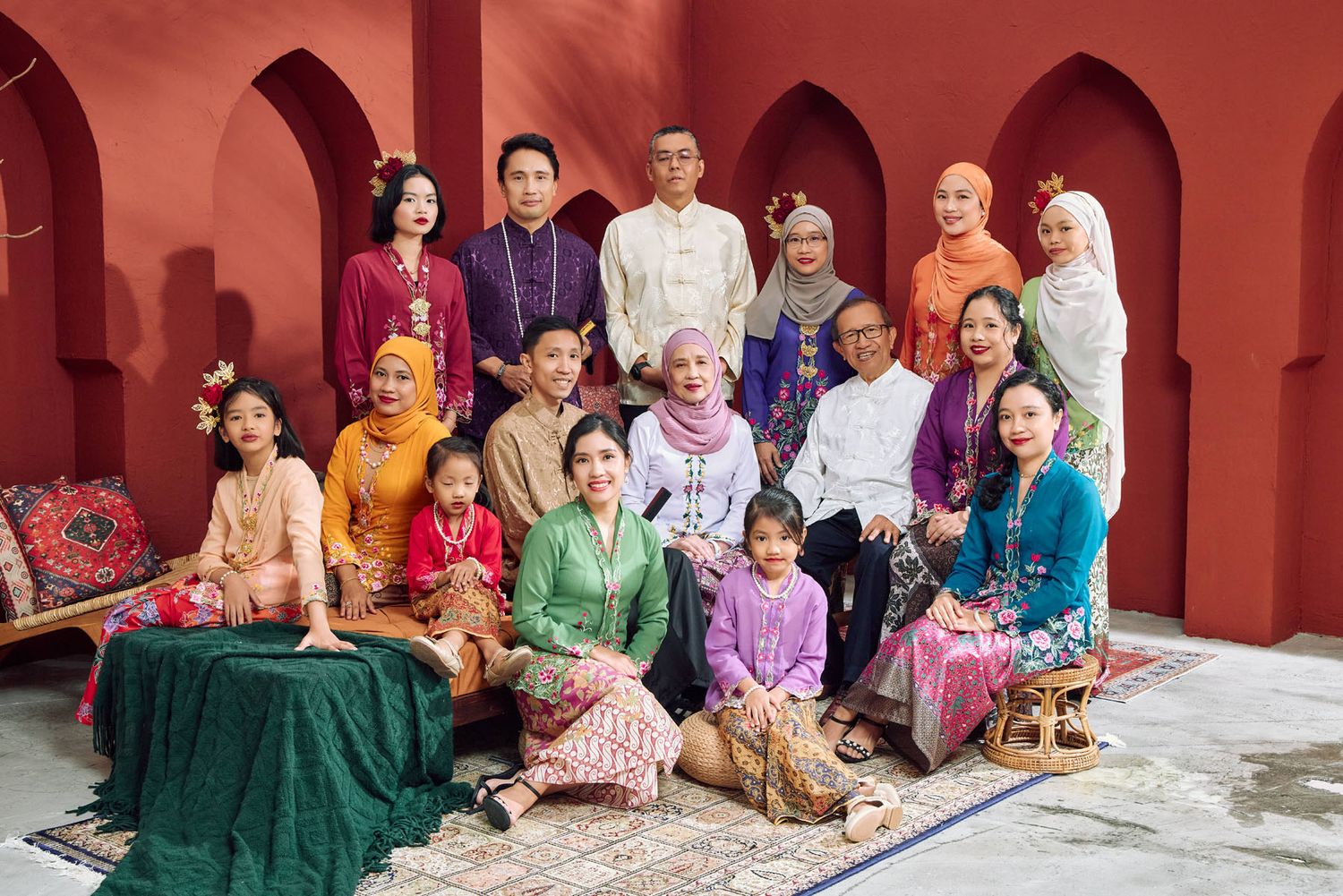 Malaysian family in colorful traditional Kebaya and Baju Kurung posing for festive Raya portrait.