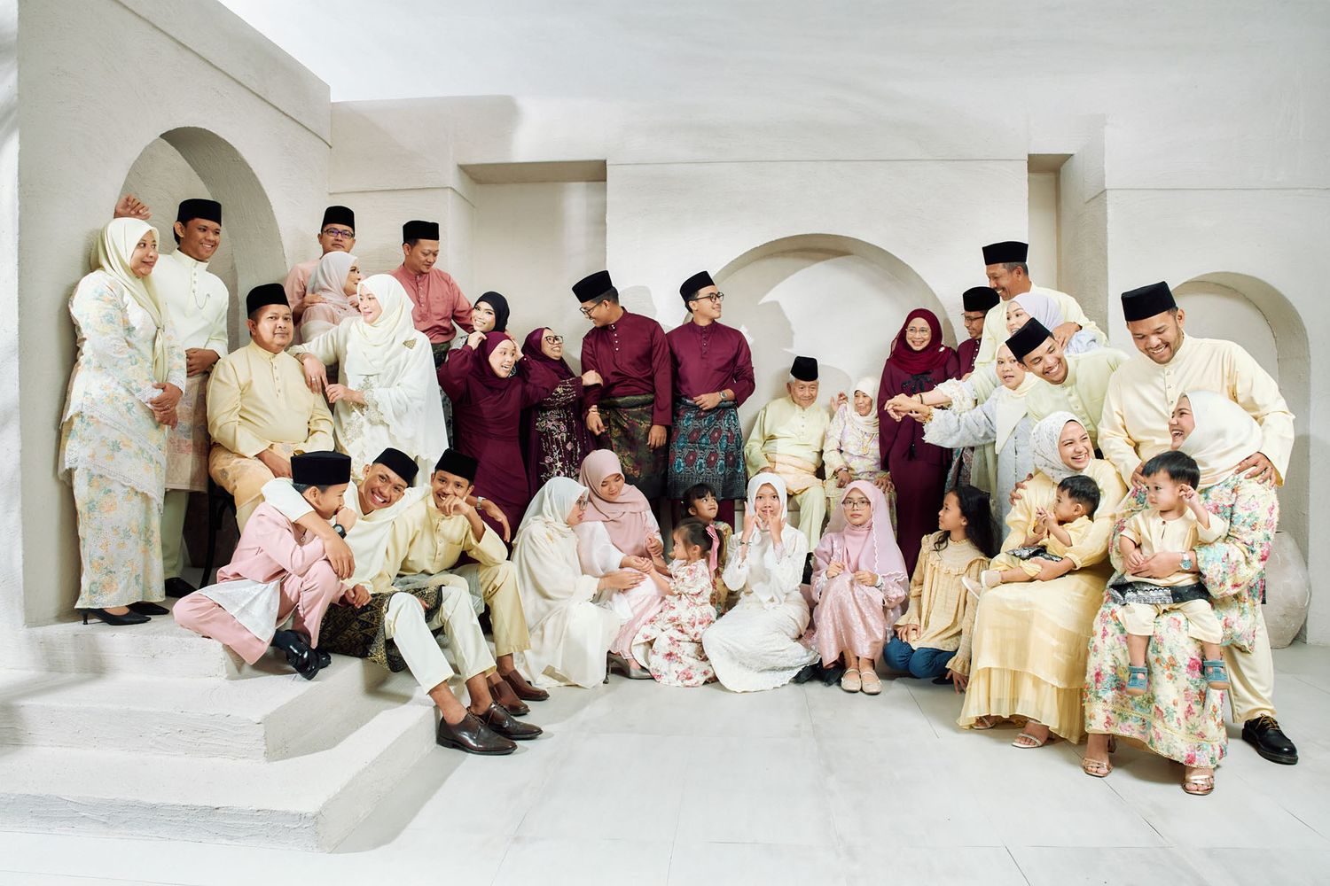 Large Malaysian family group portrait in traditional Baju Melayu and Baju Kurung festive attire.