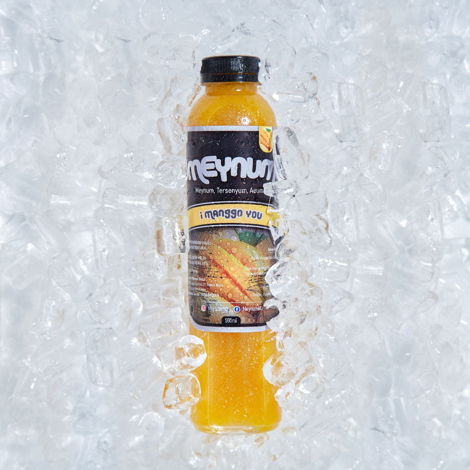 A bottle of Meynum mango juice surrounded by crushed ice on a white background.