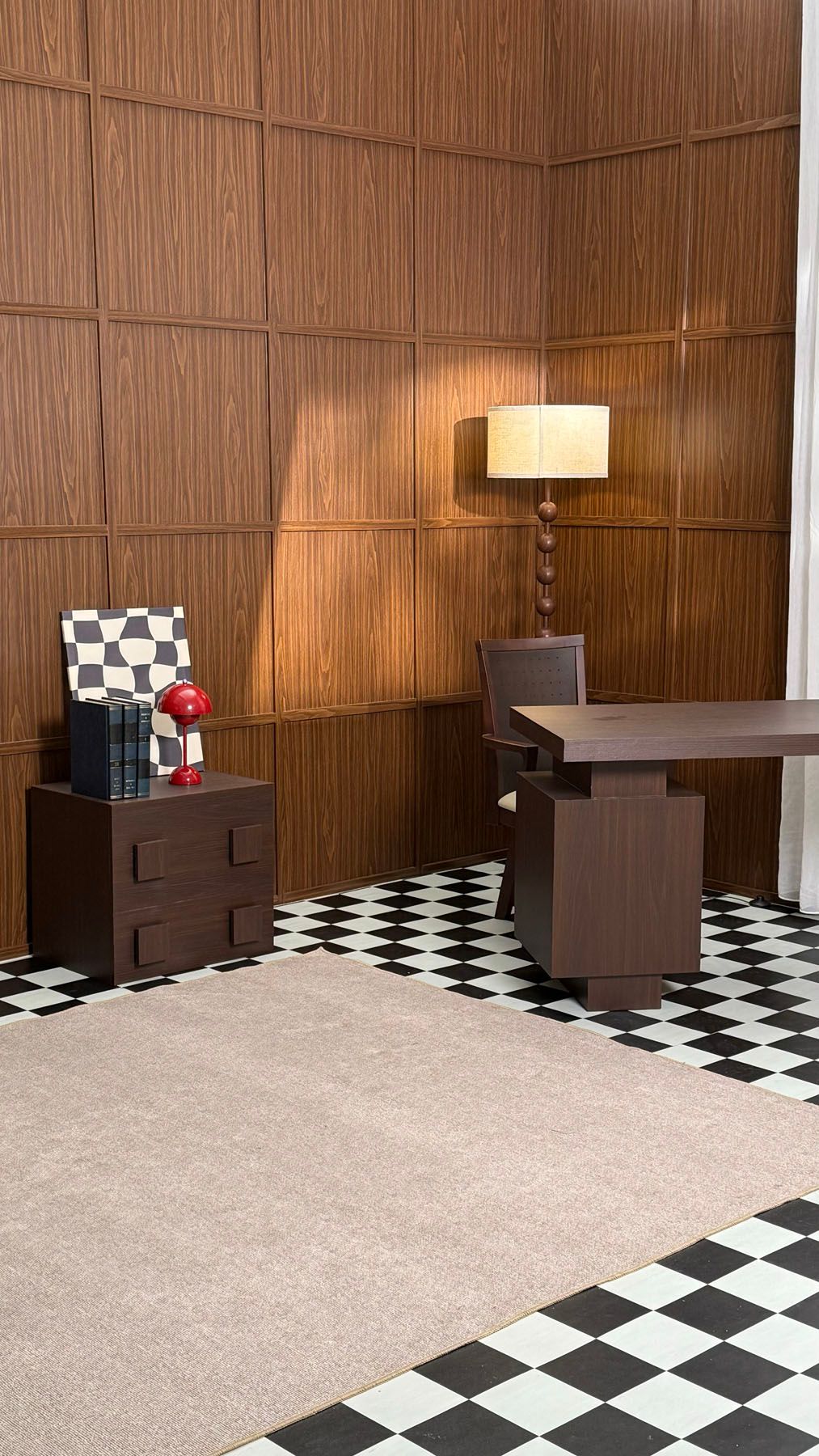 Mid-century modern office with wood-paneled walls, checkered floor, dark desk, lamp, and decorative accessories.