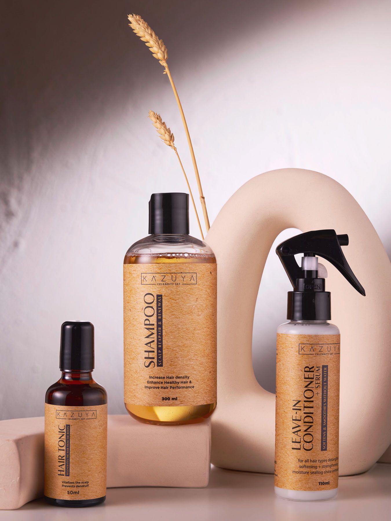KAZUYA hair care set featuring shampoo, hair tonic, and leave-in conditioner on a neutral background.
