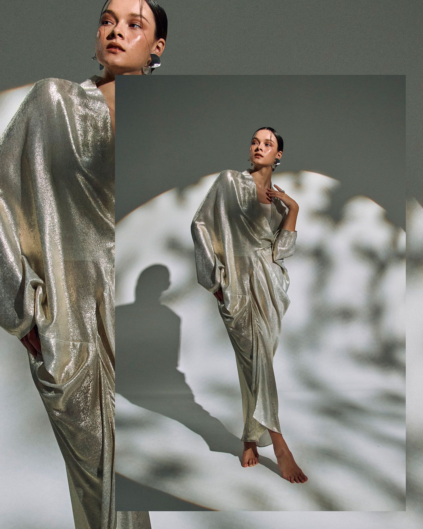 Model in flowing silver metallic kaftan dress posing in dramatic split editorial fashion shot.