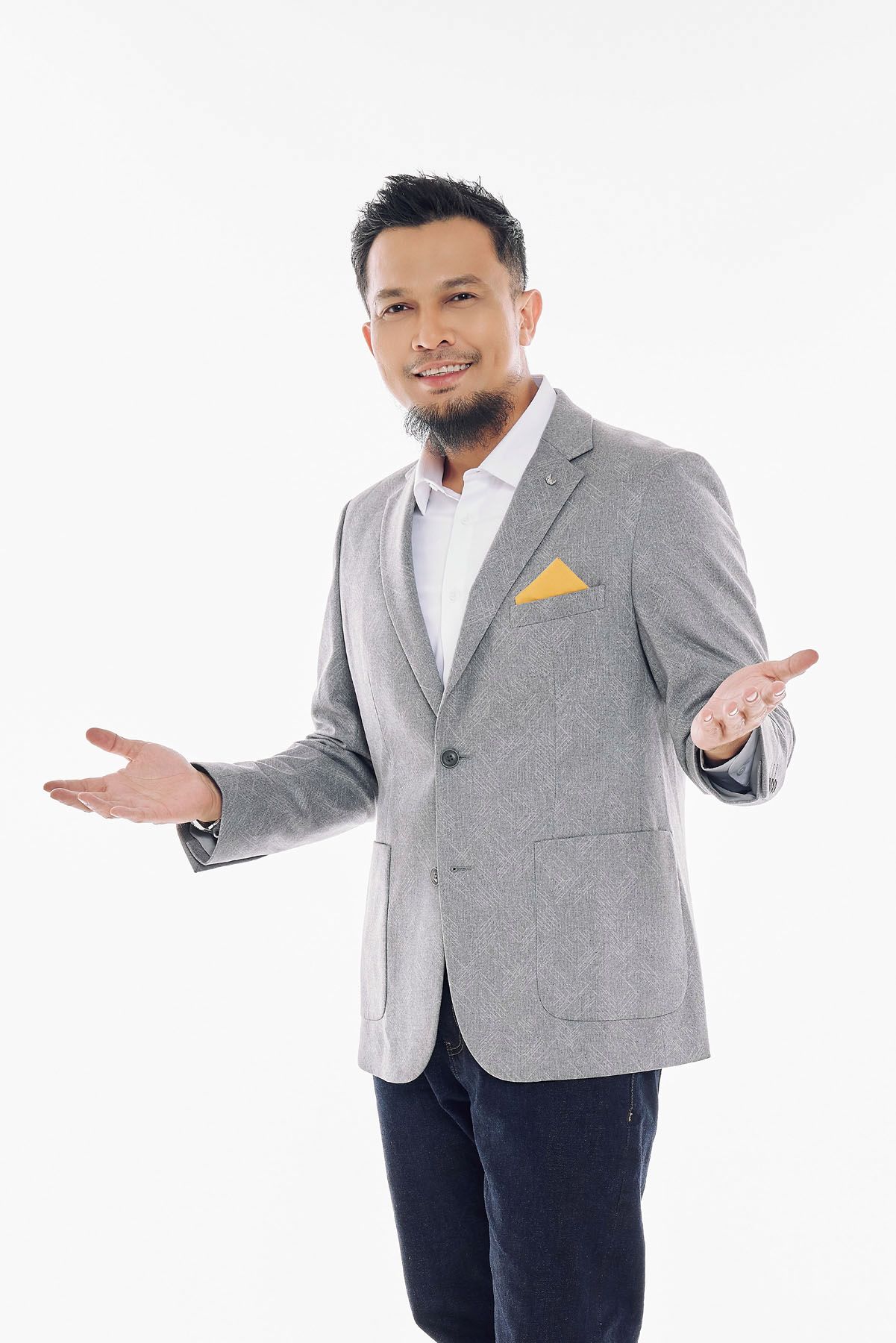 Asian businessman in gray blazer with yellow pocket square gesturing with open hands.
