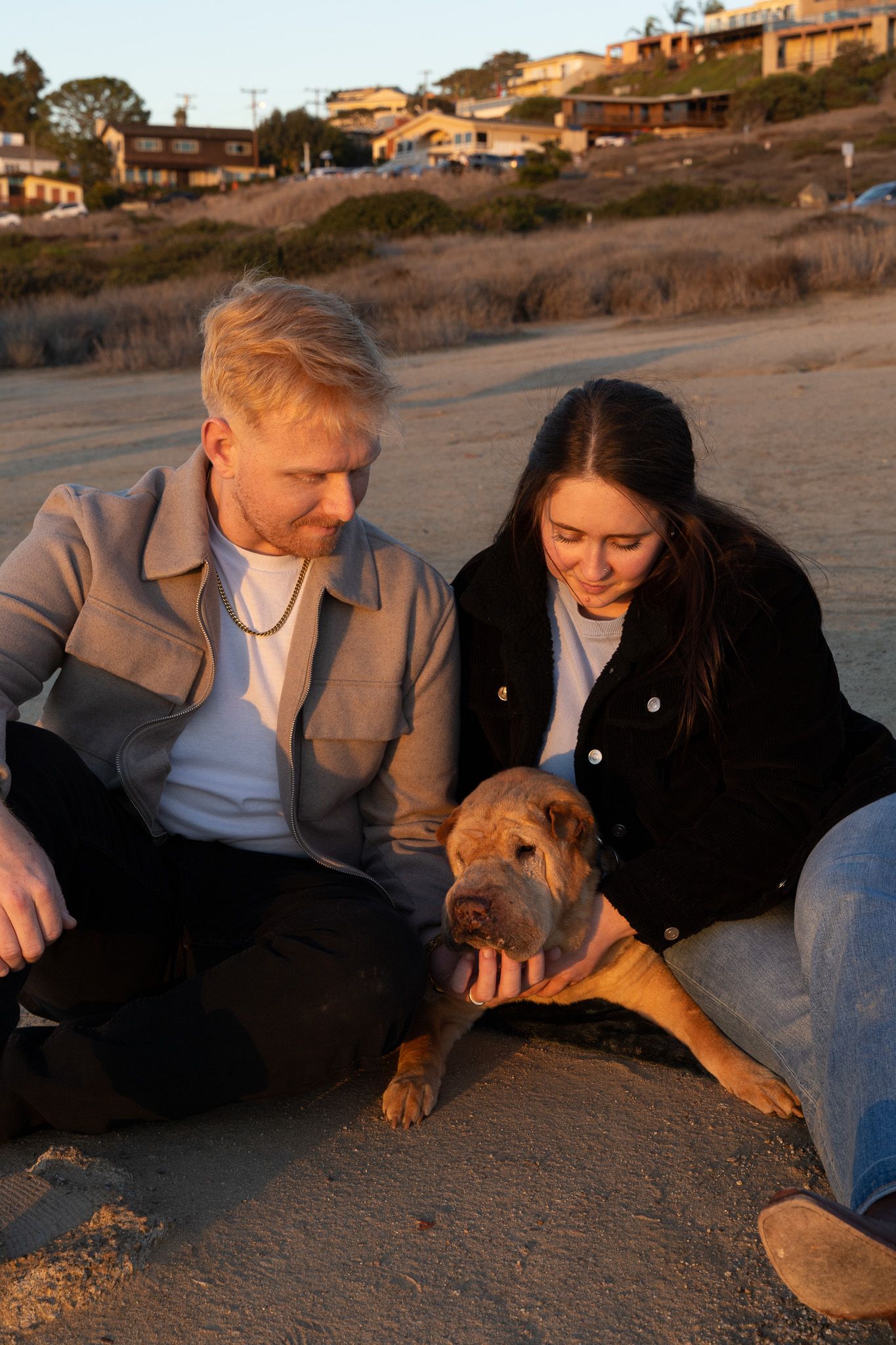 San Diego end of life pet photography session featuring a couple with their Shar Pei dog on the Sunset Cliffs beach at sunset.