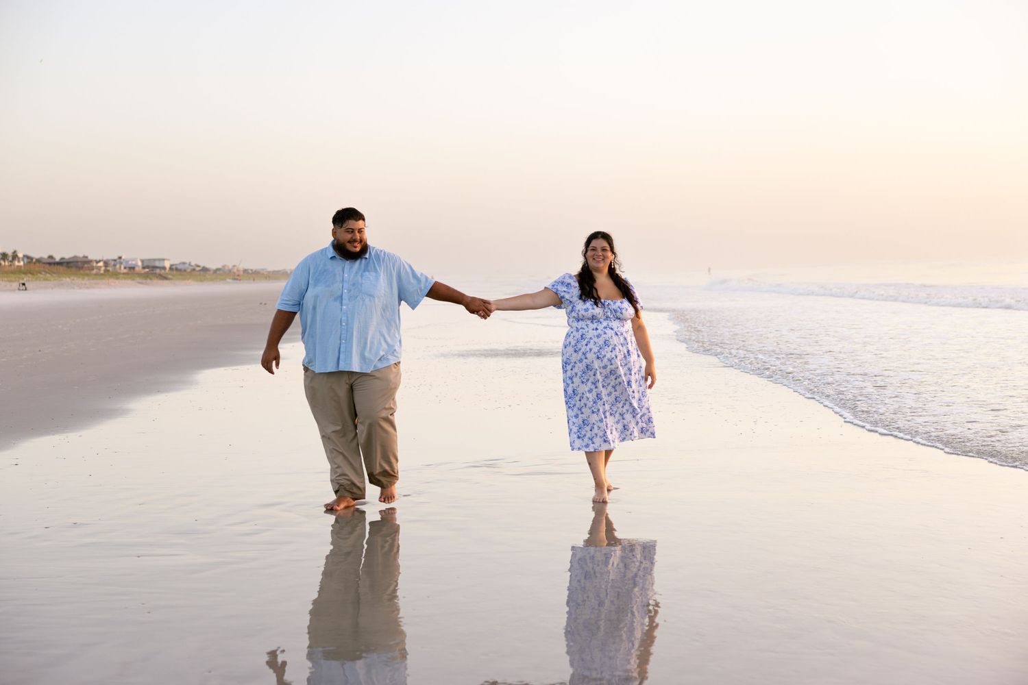 Plus-size wedding couple photography inspiration, couple holding hands while walking down the beach.