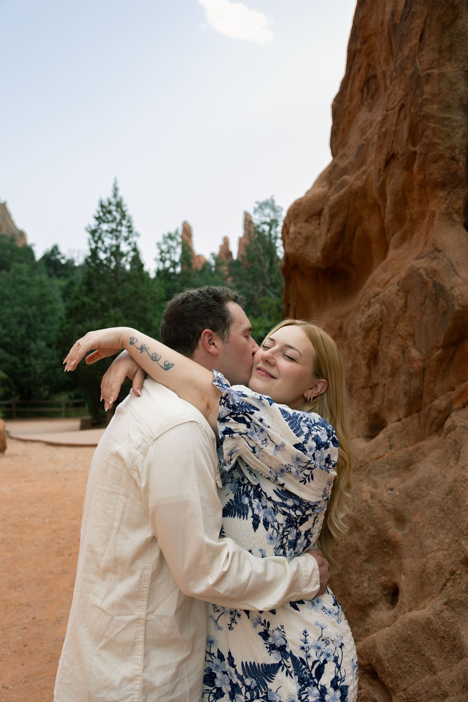 Couple embracing and kissing near red rock formations at Garden of the Gods, Colorado.