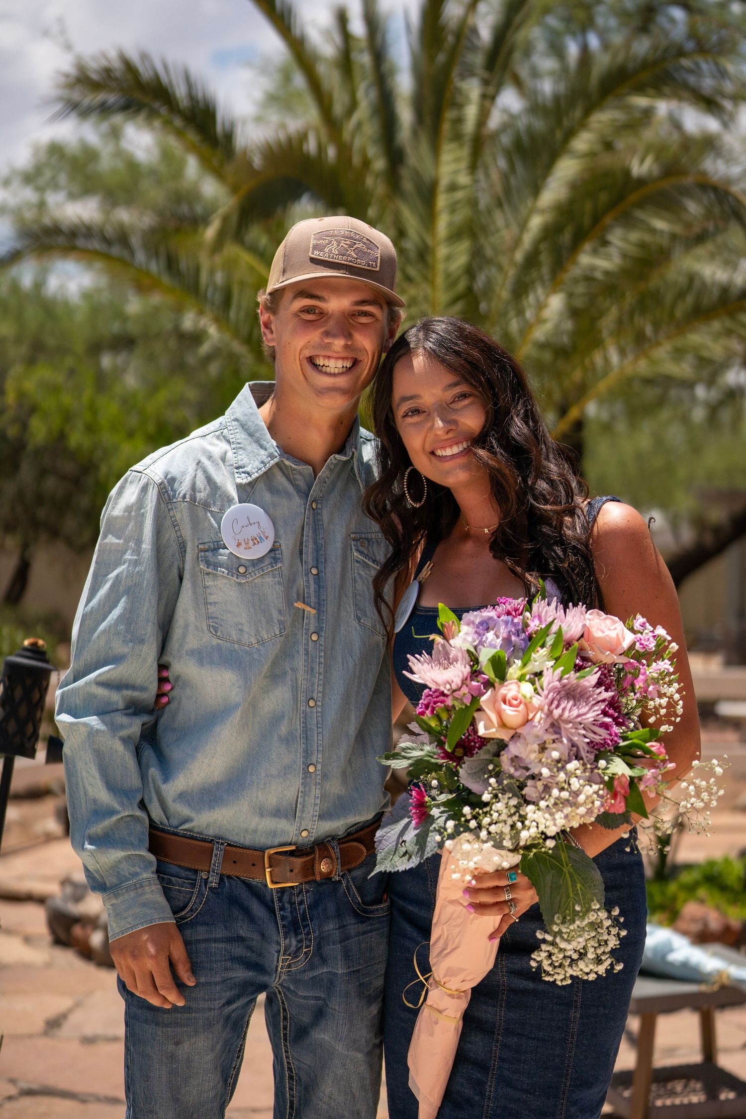 Couple standing close together holding flowers