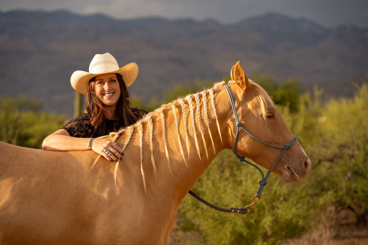 Cowgirl smiling at the camera in the golden hour desert