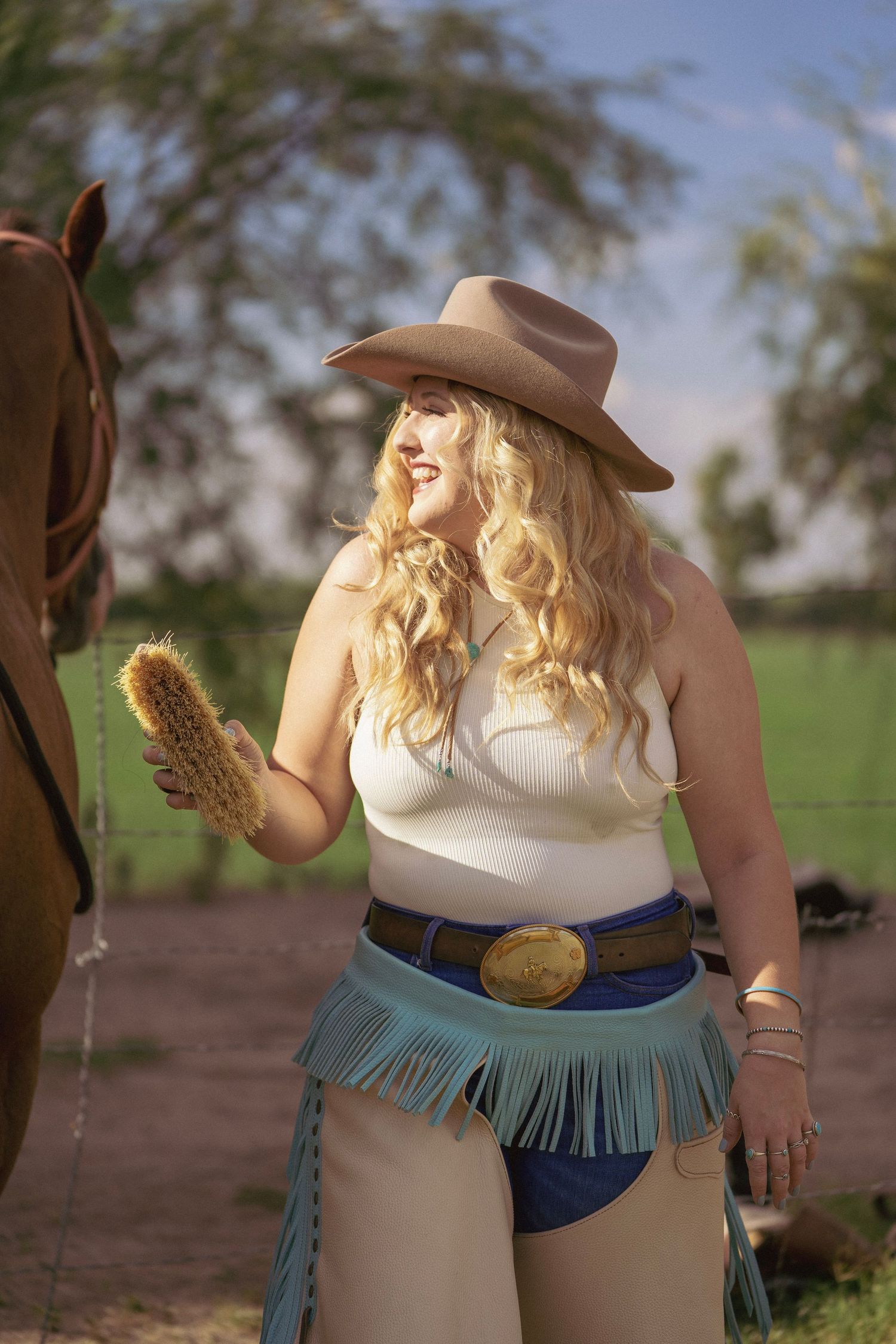 Cowgirl brushing her horse