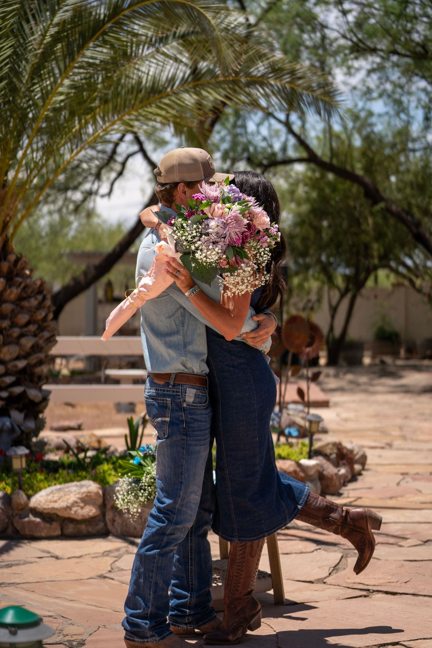 Couple standing close together holding flowers