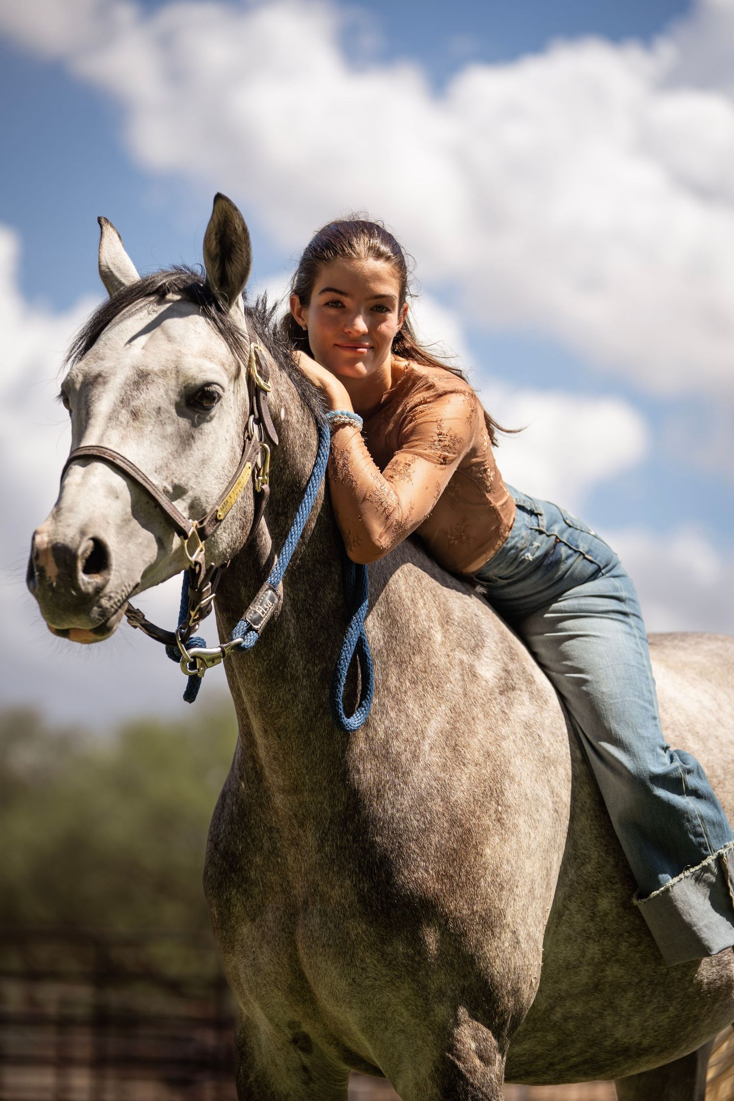 Girl sitting on horse bareback in field photoshoot
