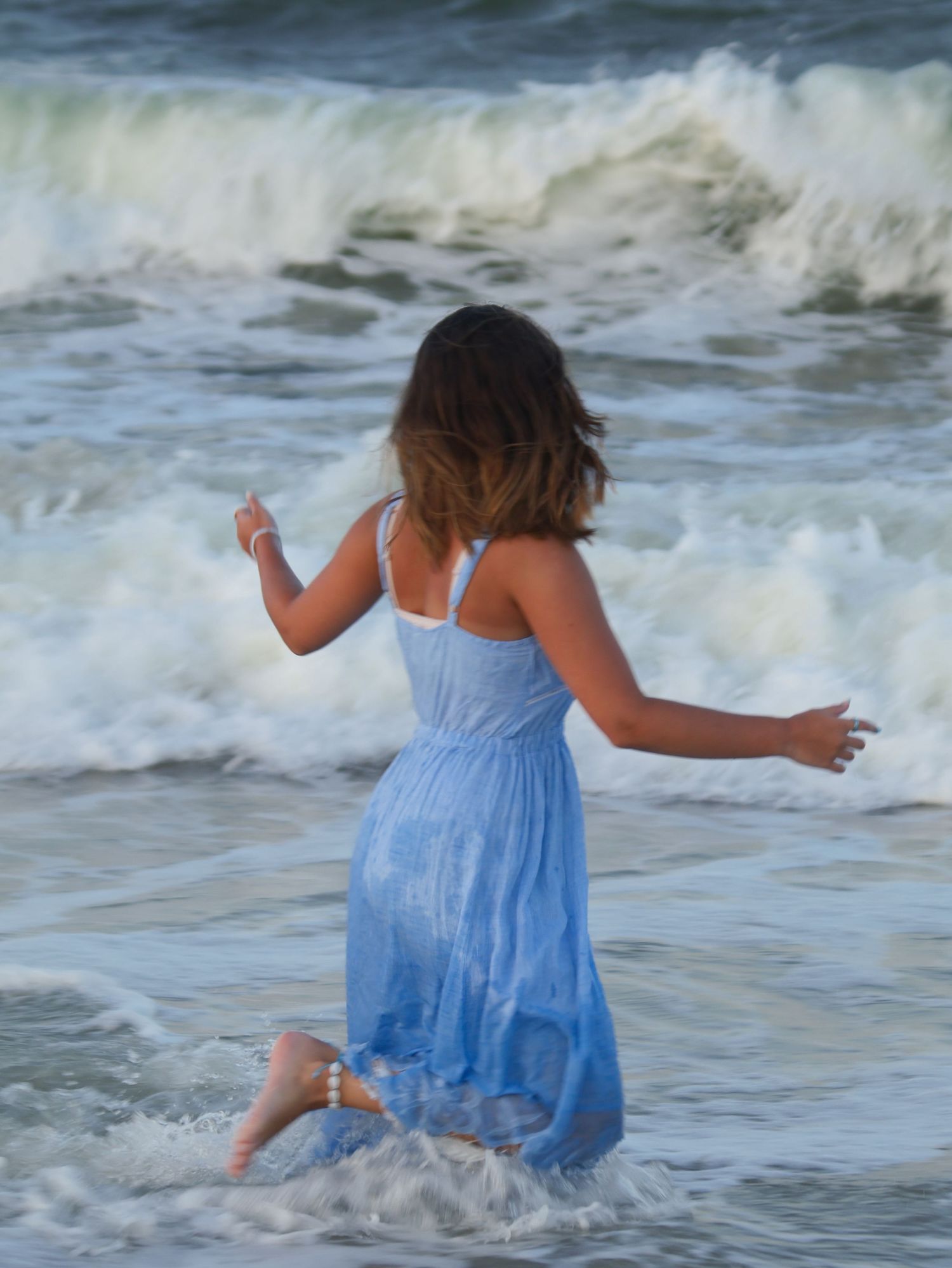 girl running in water looking away