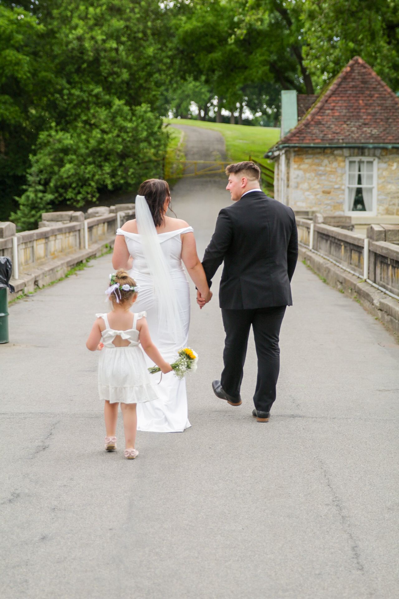 couples walks away holding hands as the flower girl follows at berks county wedding