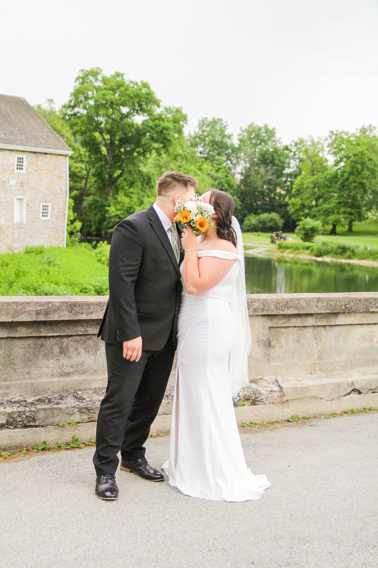 couple kissing with flowers covering their face at berks county wedding