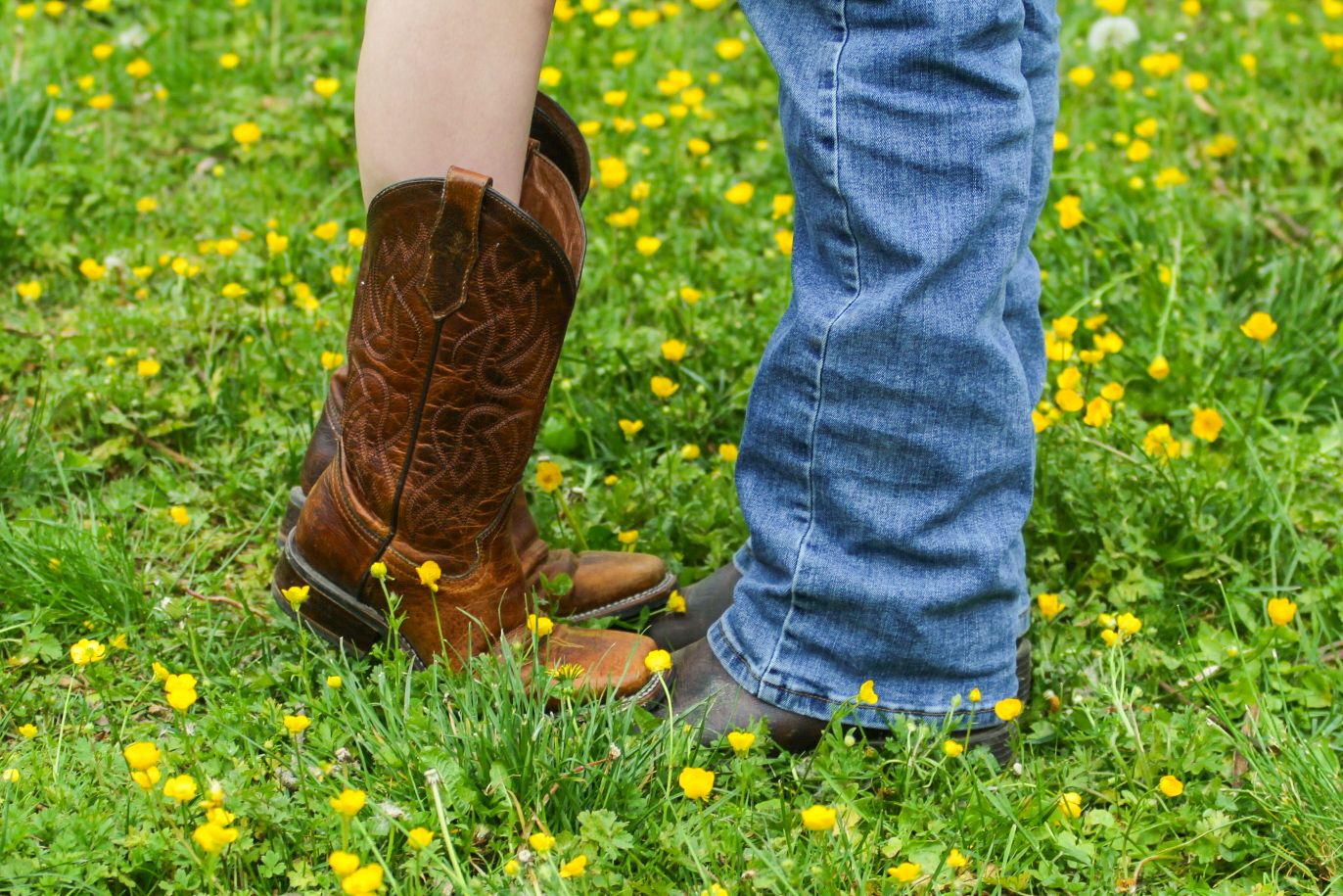 boots and jeans in a field of flowers at berks county couples photoshoot