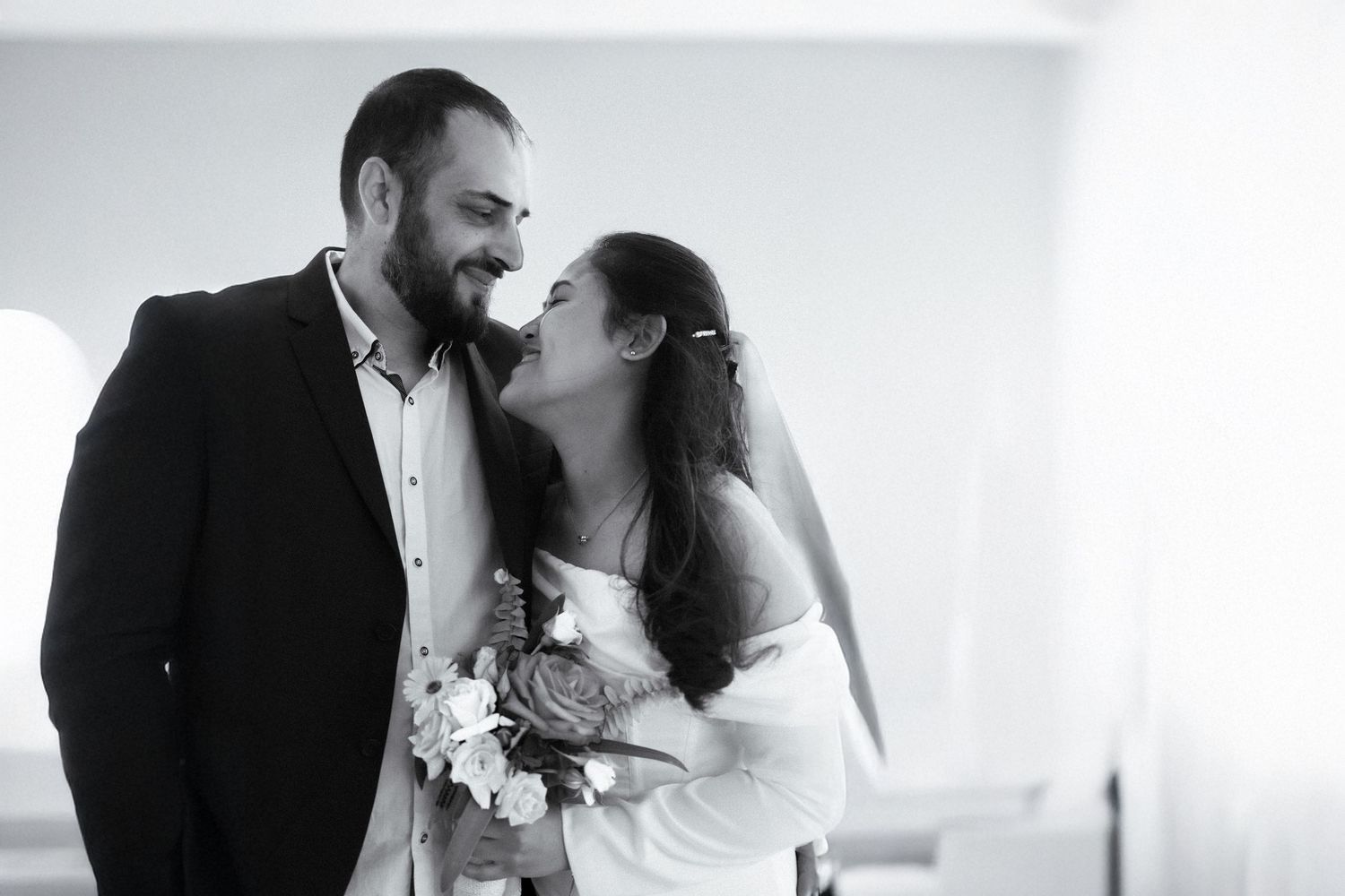 Emotional black and white wedding photo of bride and groom celebrating their marriage