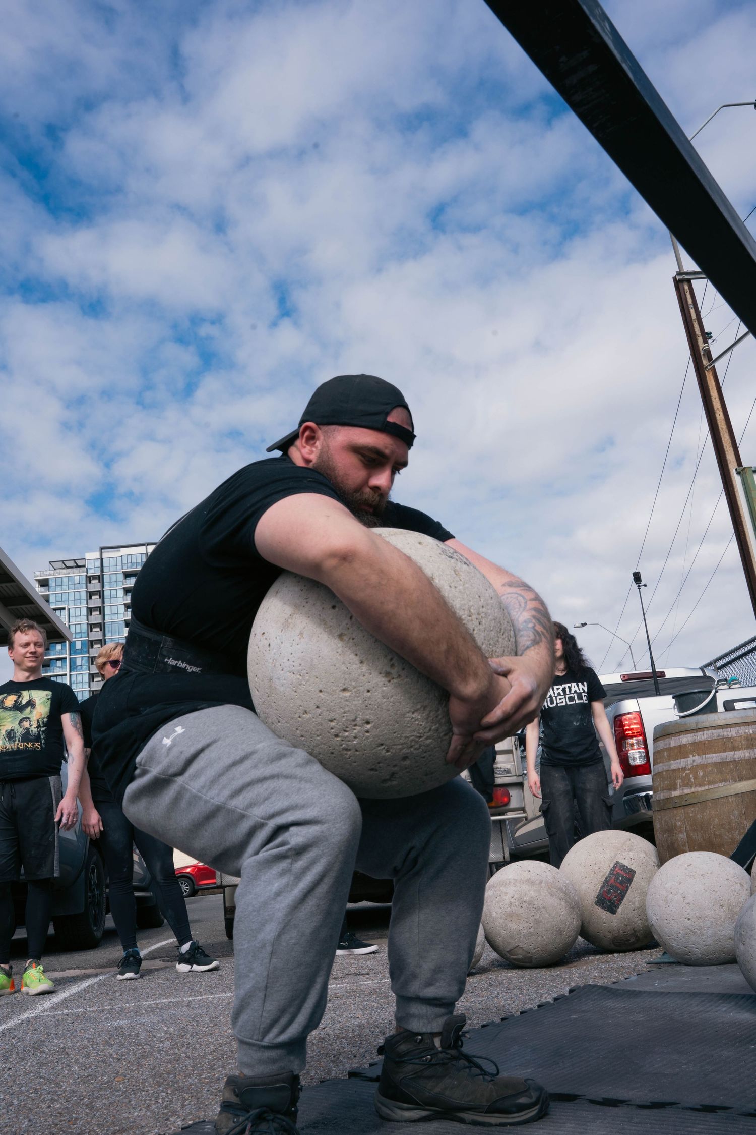 Athlete lifting heavy Atlas stone during strongman seminar in Adelaide