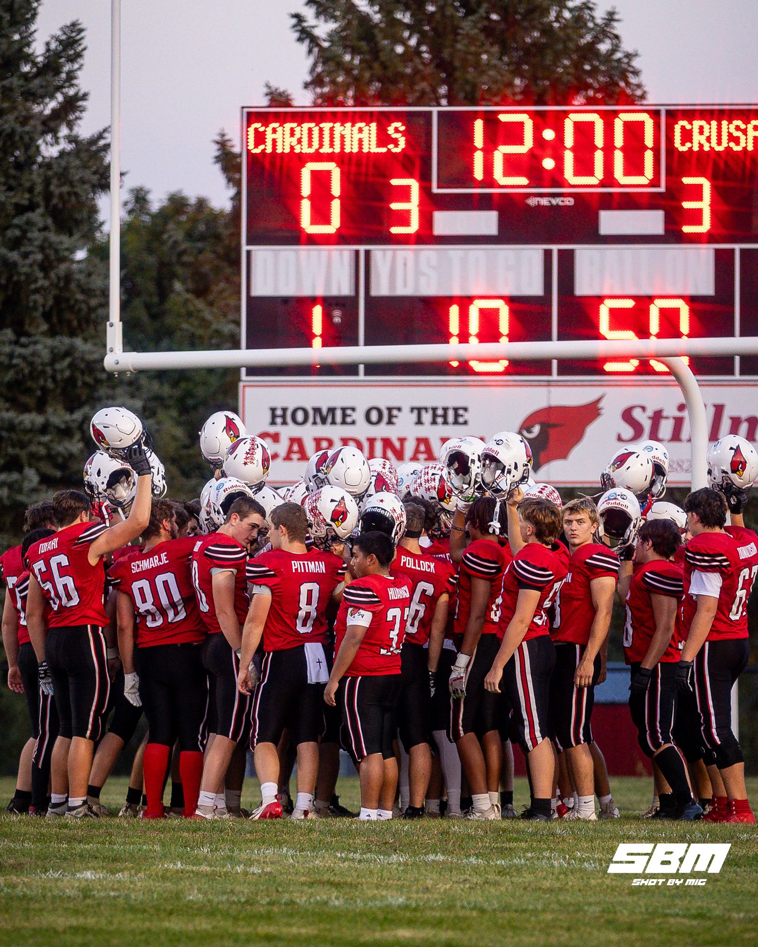 Stillman Valley varsity football lined up on field under the stadium scoreboard before the match.