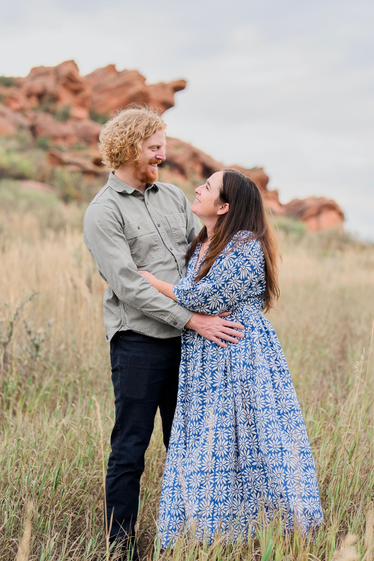 Portrait of a couple smiling and holding each other in an outdoor photo session at Lory State Park.