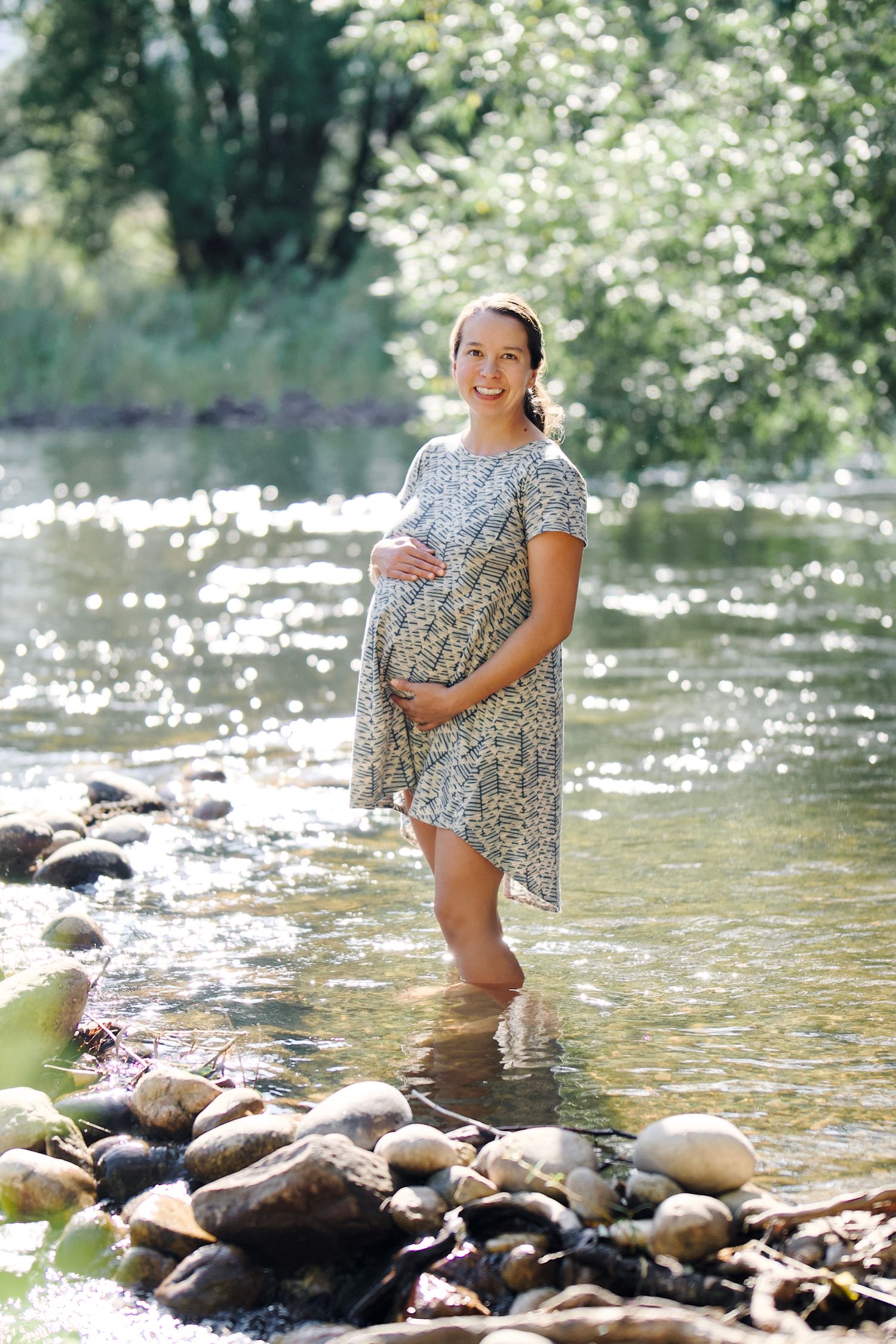 A maternity portrait of an expecting mother outdoors in a calm portion of the Poudre River in Fort Collins, Colorado.