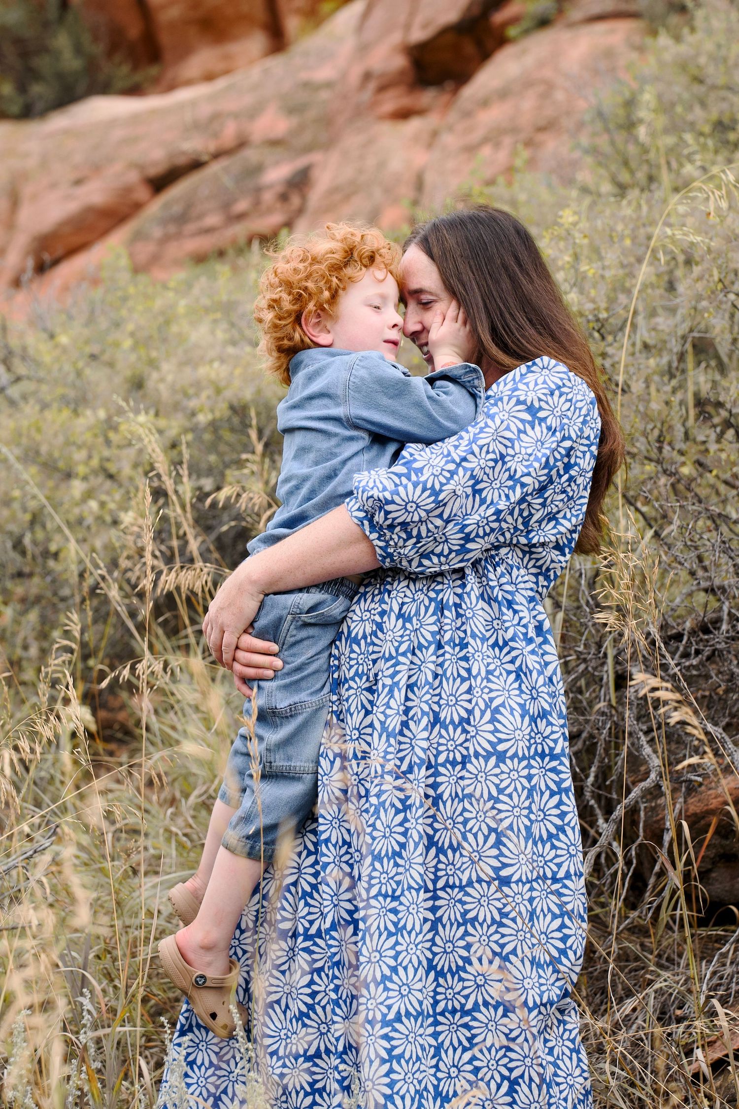 Portrait of a mother and young boy smiling and holding each other in an outdoor photo session at Lory State Park.