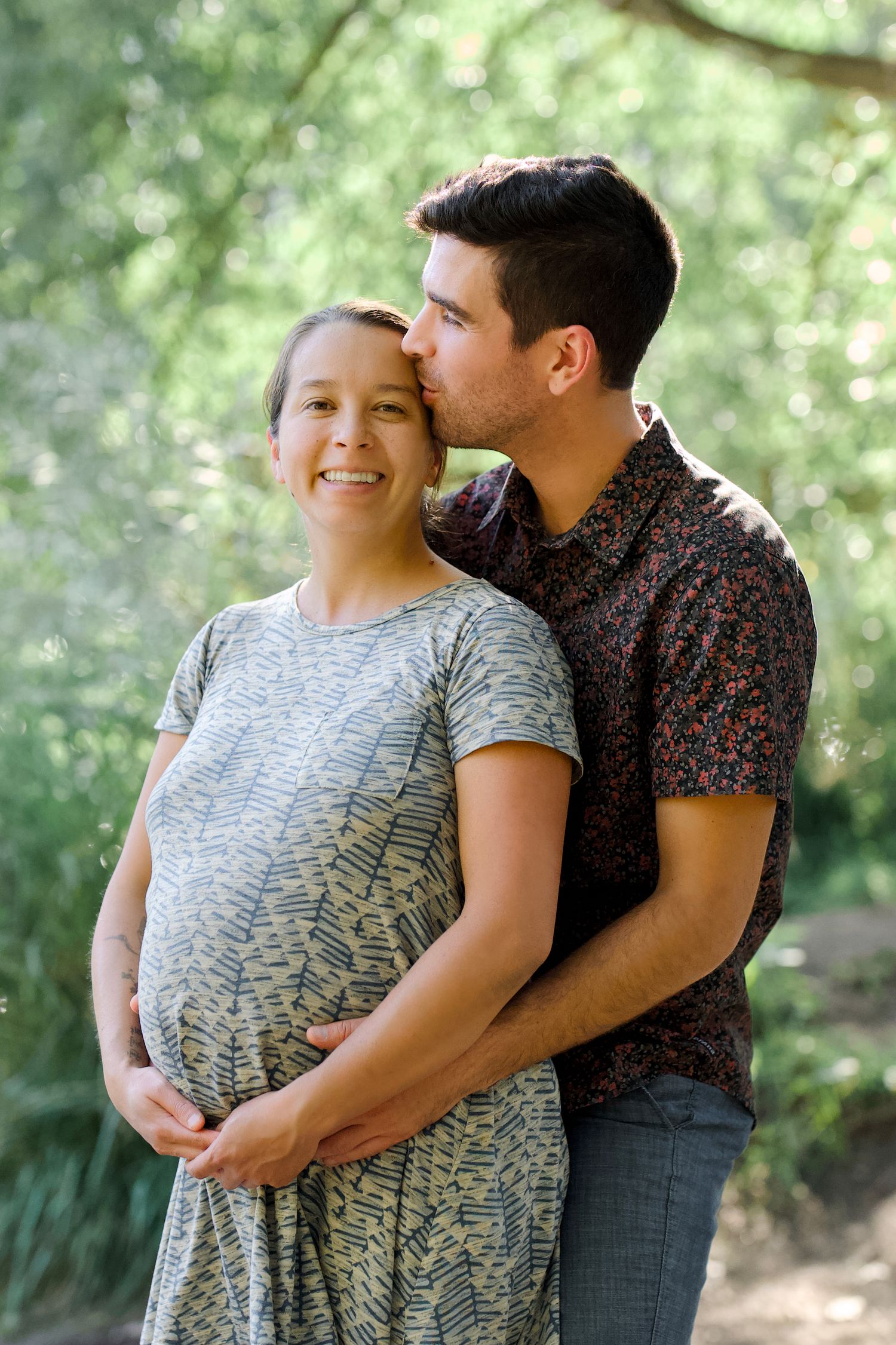 A maternity portrait of an expecting mother with her husband outdoors by the Poudre River in Fort Collins, Colorado.