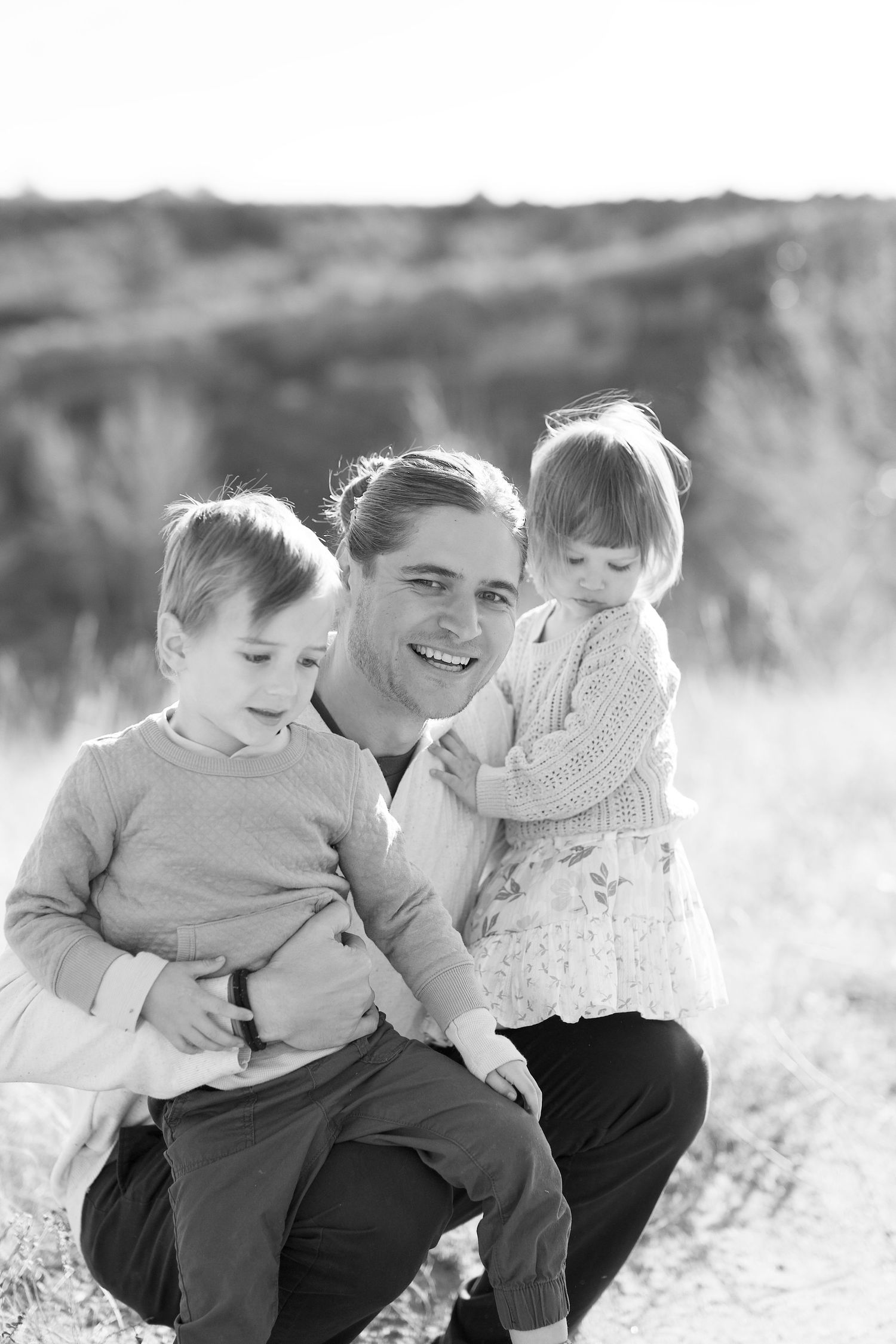 Black and white portrait of a father and two children outdoors at Lory State Park.