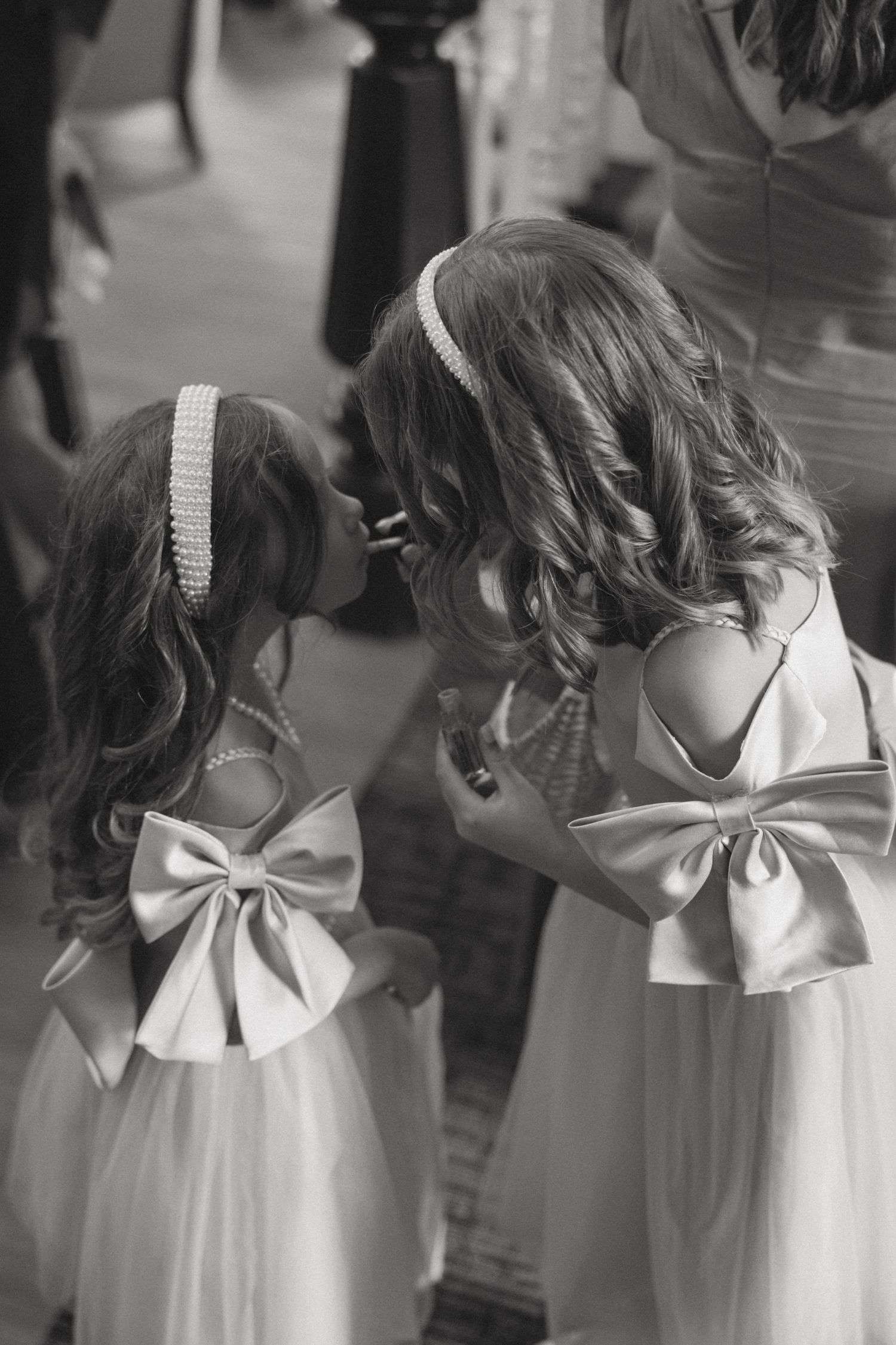 A series of black and white photos showing the back details of a white dress with a decorative bow accent.