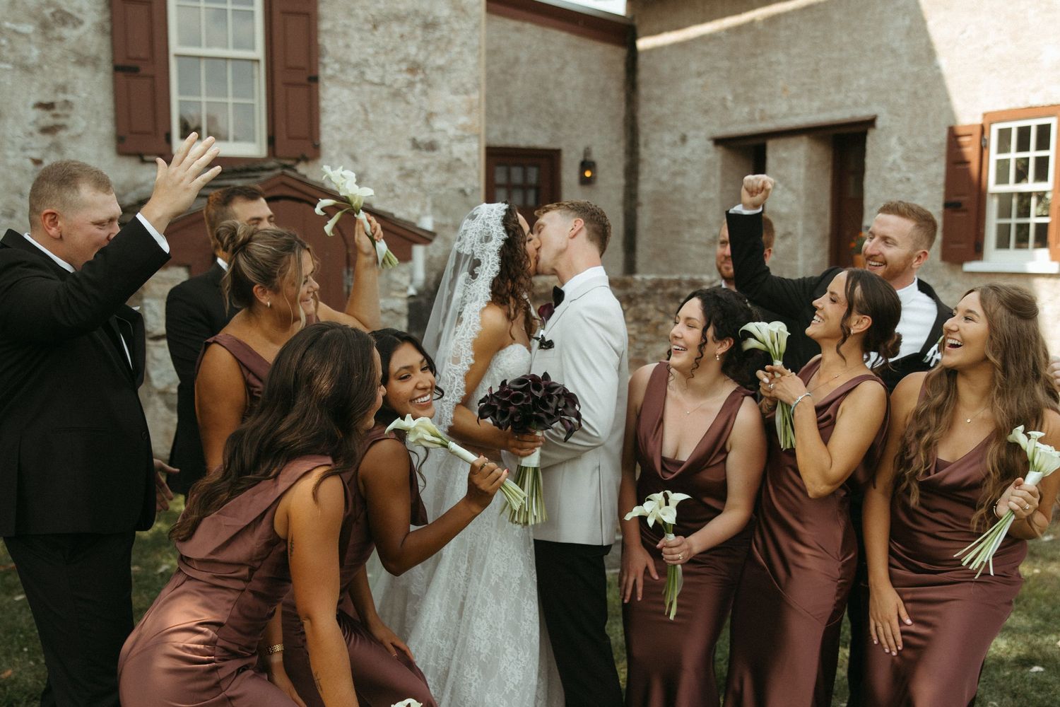 Wedding party members in brown dresses toast with champagne glasses during an elegant celebration.