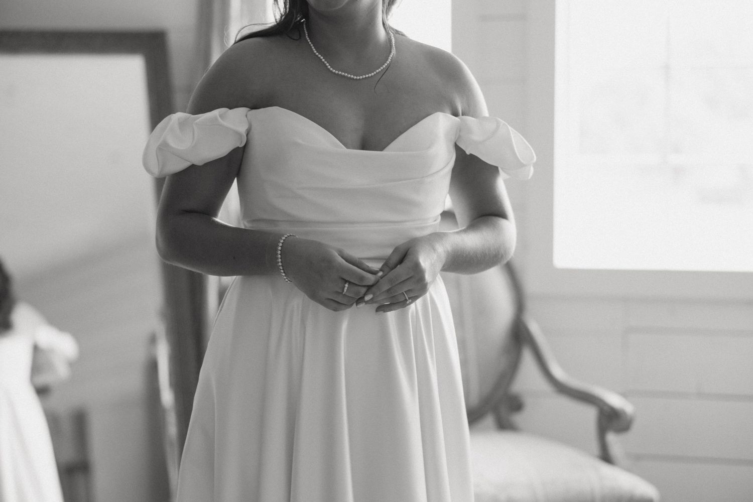 Elegant white bridal gown details showing off-shoulder neckline and bodice.