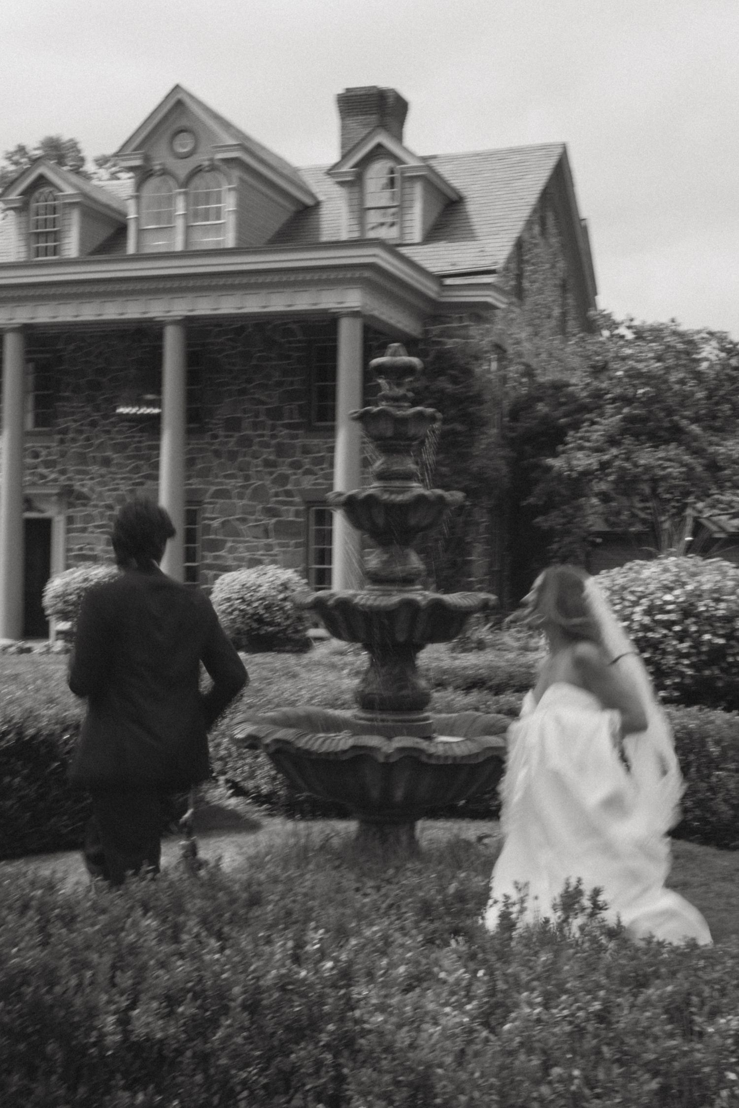 A series of black and white photographs showing people walking through a lush garden with stone buildings in the background.