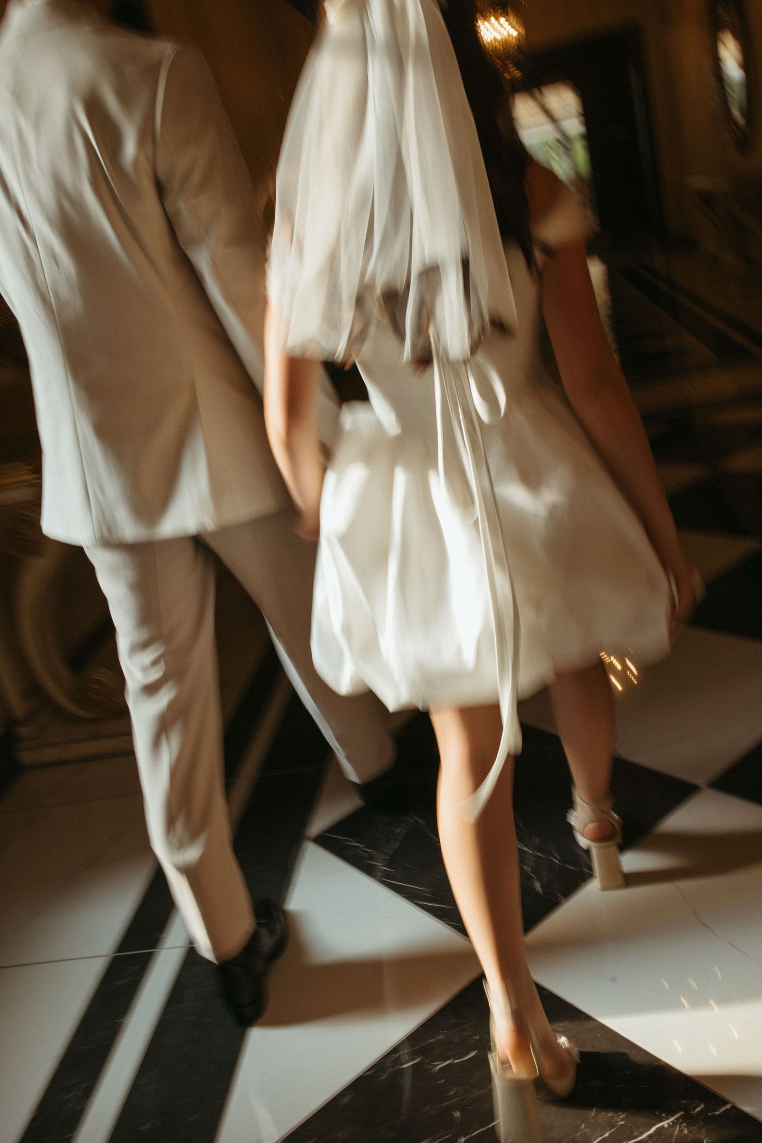People in white clothing dancing and moving on a dance floor with dramatic lighting.