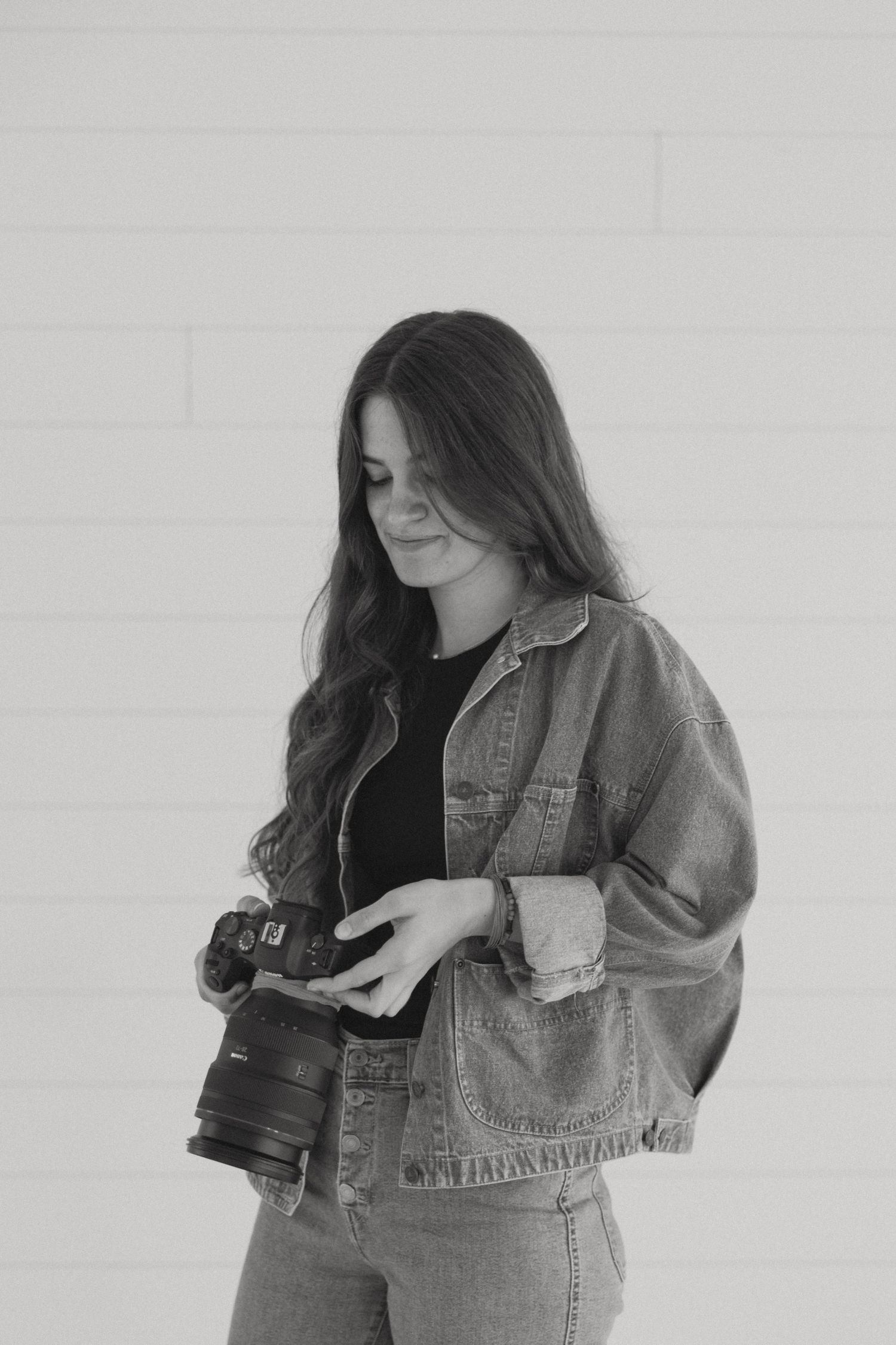 Black and white photos of photographer with camera in denim jacket.