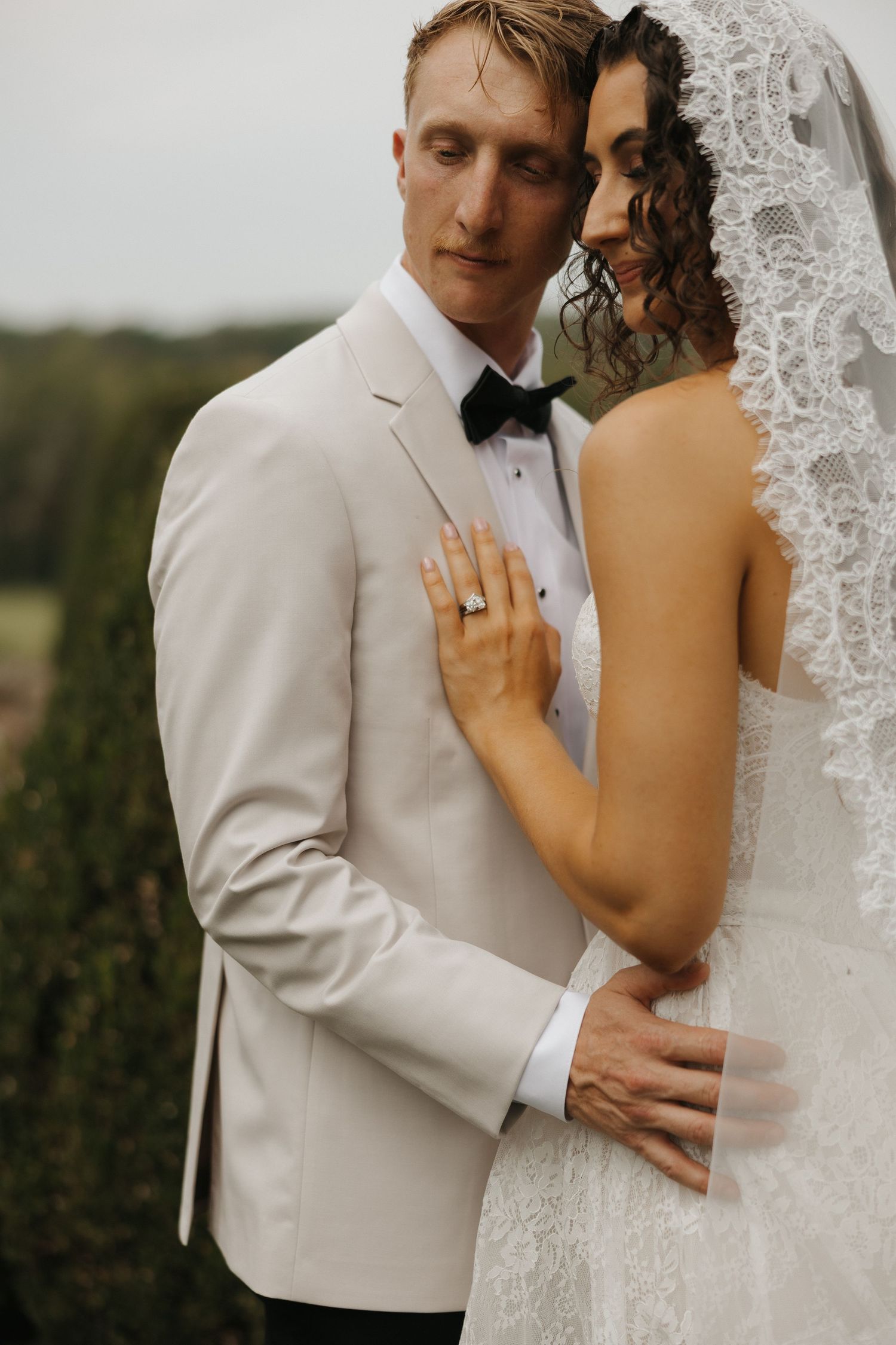 A romantic wedding portrait series showing tender moments between a couple in white formal attire and lace.