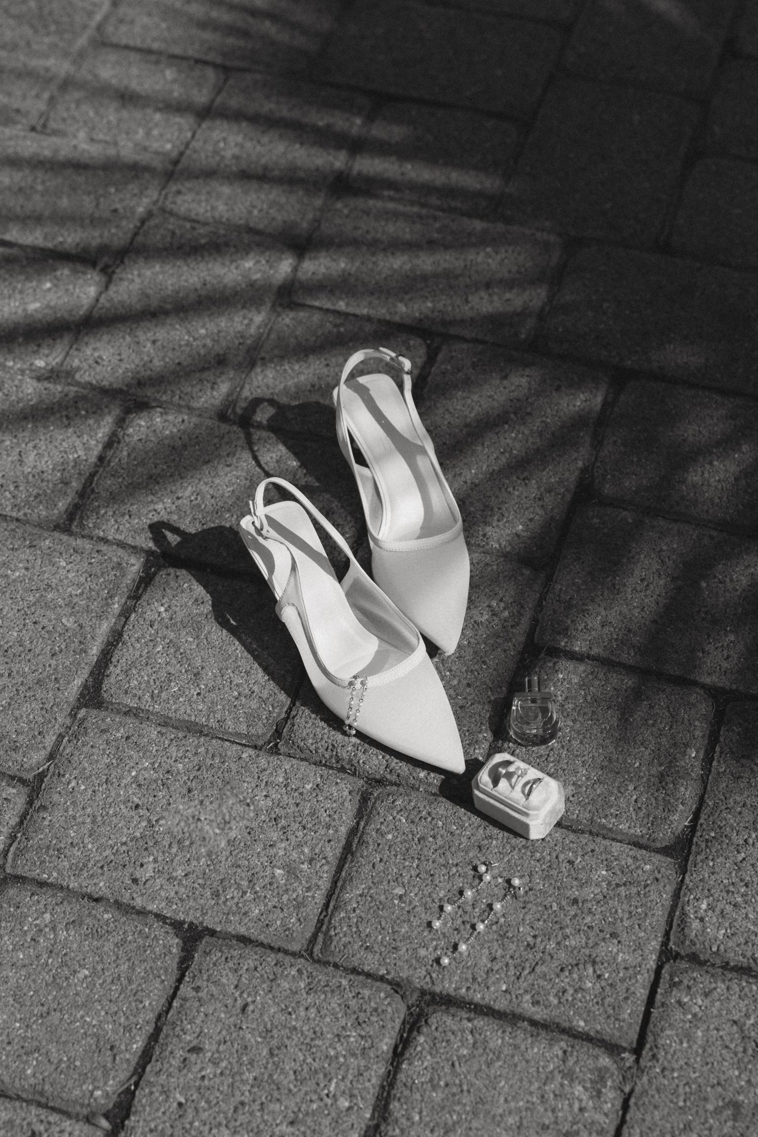 A sequence of black and white photos showing white shoes casting dramatic shadows on stone pavement.