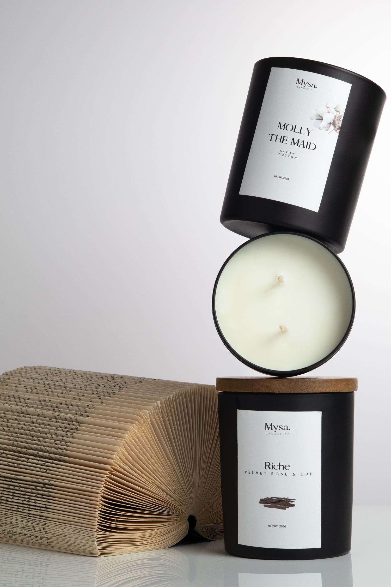 Editorial candle still life with stacked candles and book photography by UK product photographer Glow Studio Yalda