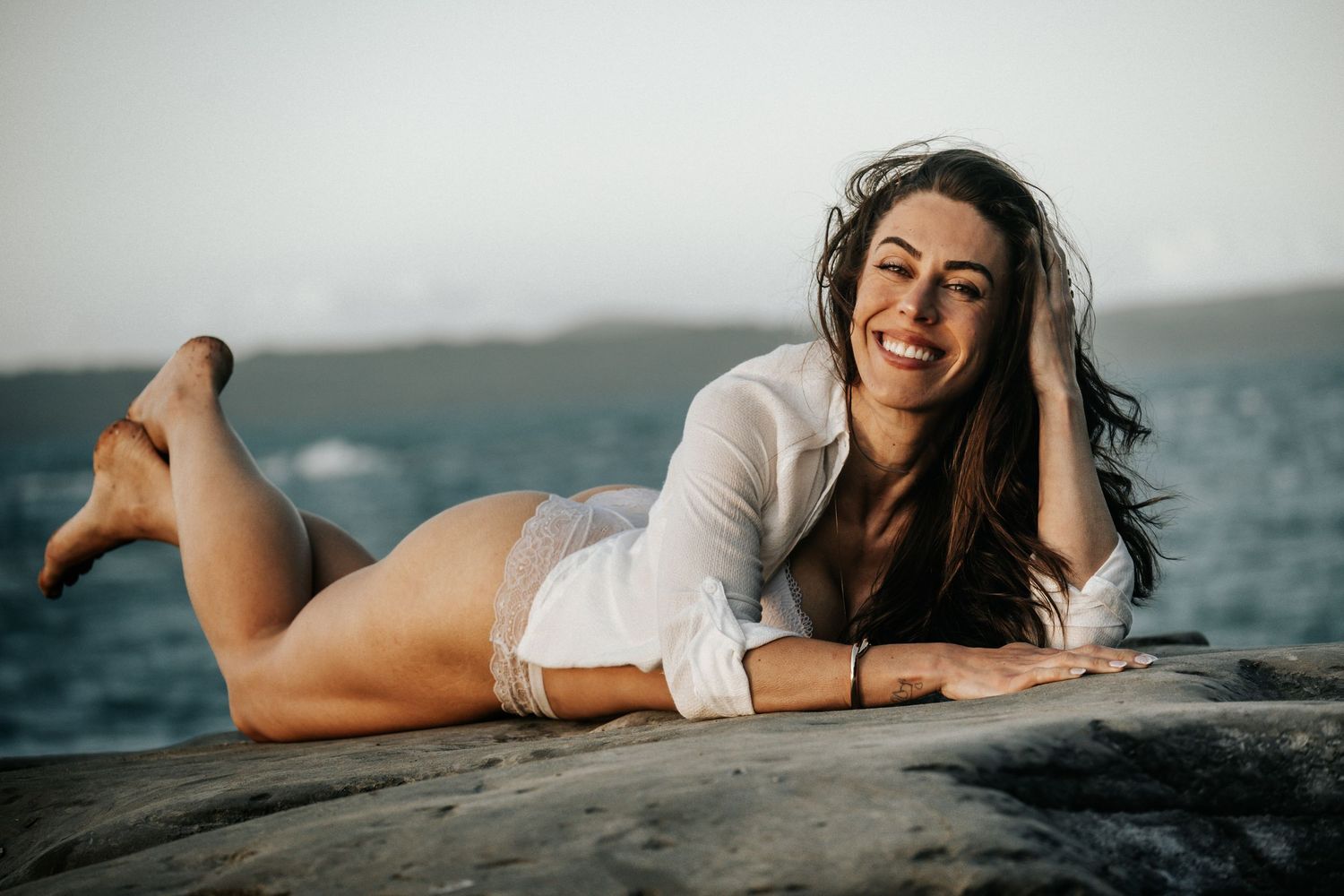 A series of beach portraits showing someone laying on the sand with ocean waves in the background.